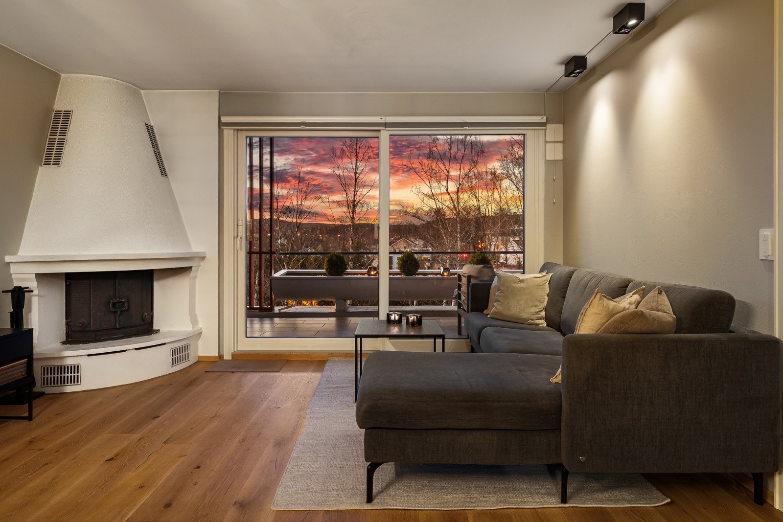 Stuen har pen enstavs eikeparkett på gulv og flott hjørnepeis som varmer godt hele året Galleribilde