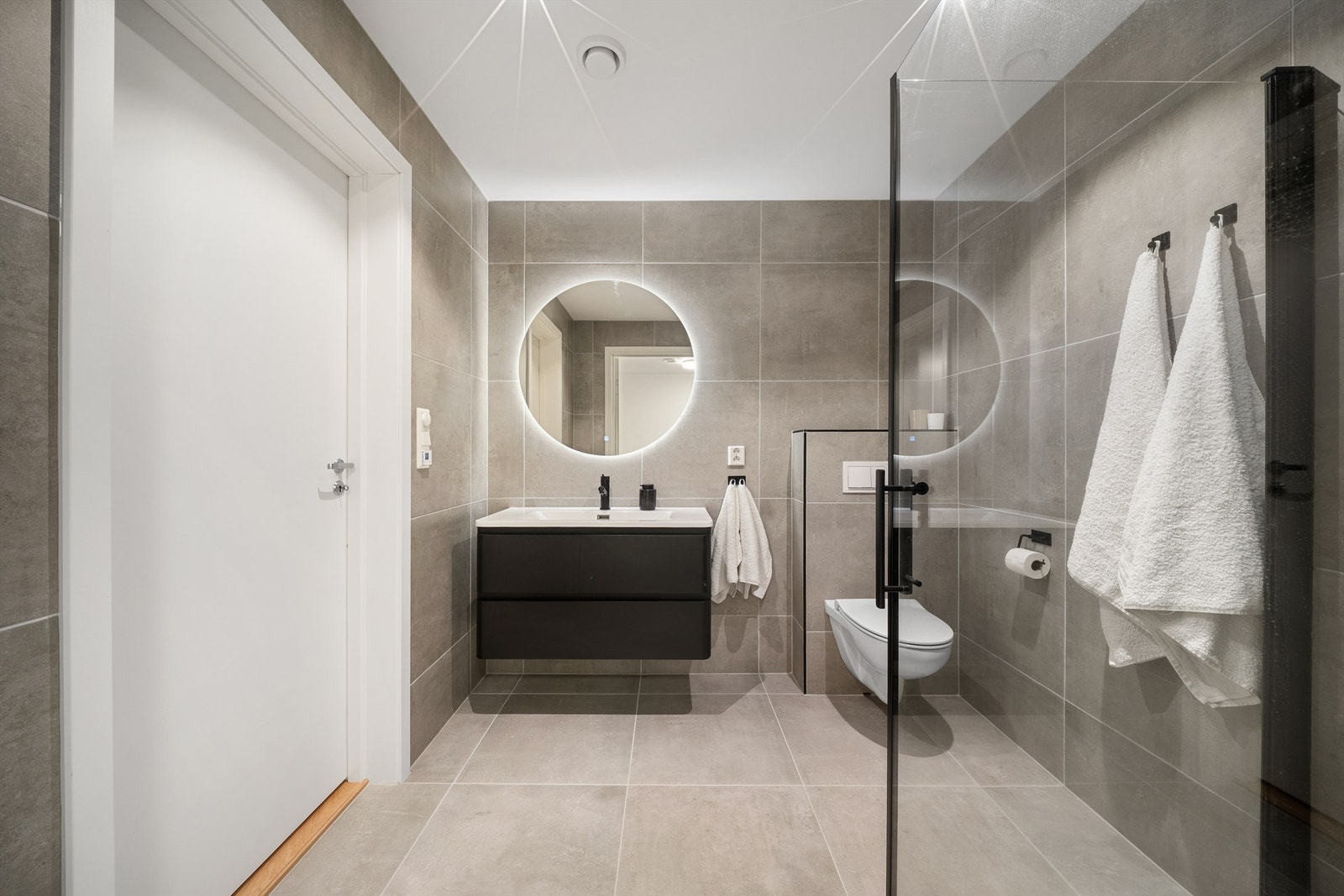 Like overflater og innredninger gir en rød tråd mellom boligens to lekre bad. Galleribilde