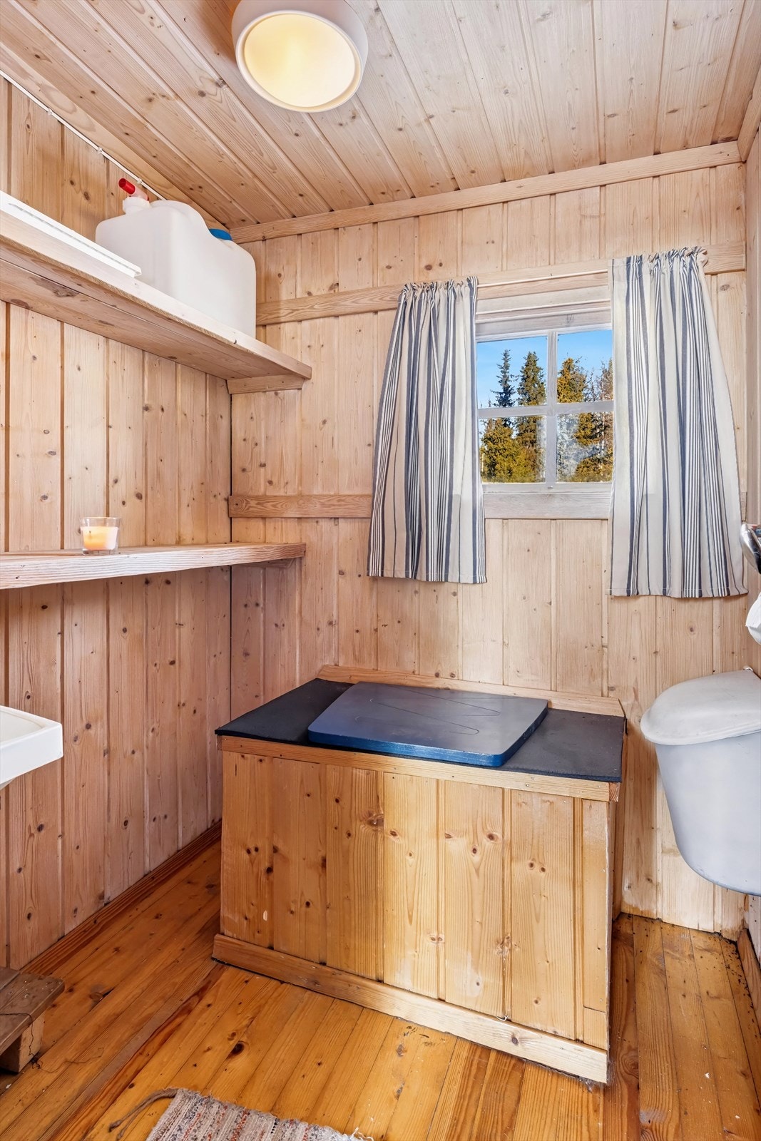 Utedoen har også plassbygde hyller for oppbevaring av eksempelvis toalettruller og vanndunk. Galleribilde