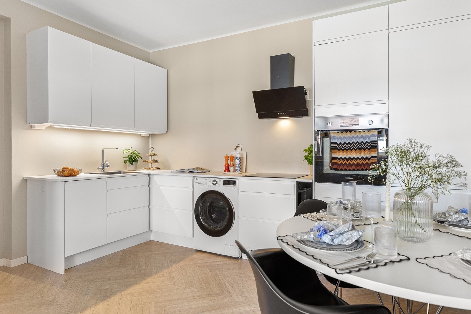 Det er laminerte benkeplater, slette skapfronter og malt backsplash Galleribilde