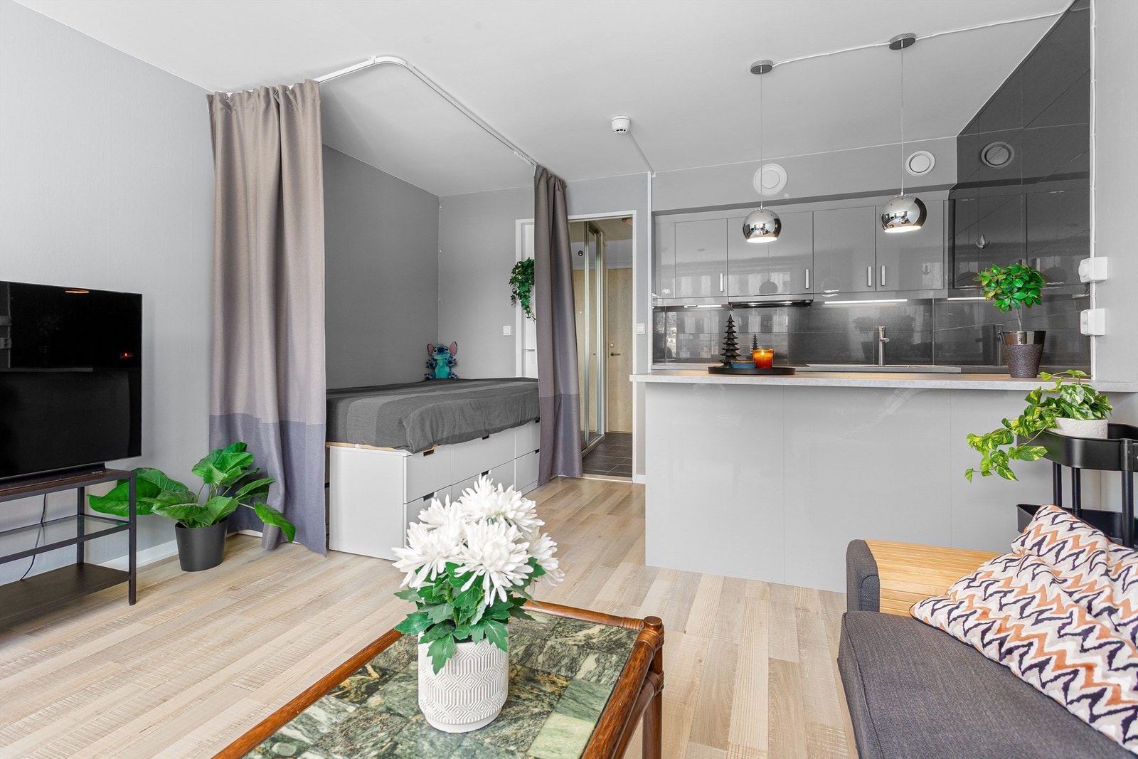 Stue med sofaområde og sengeplass (opplegg for forheng rundt sengen) Galleribilde