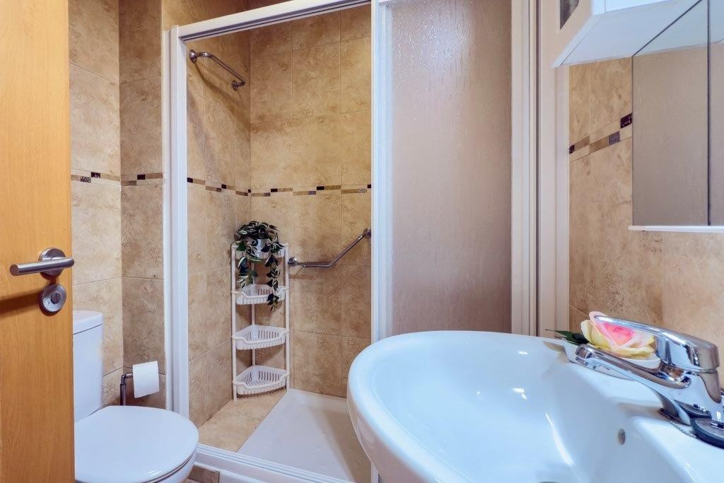 Meget pent helfliset bad med dusj, toalett, vask, og vaskemaskin Galleribilde