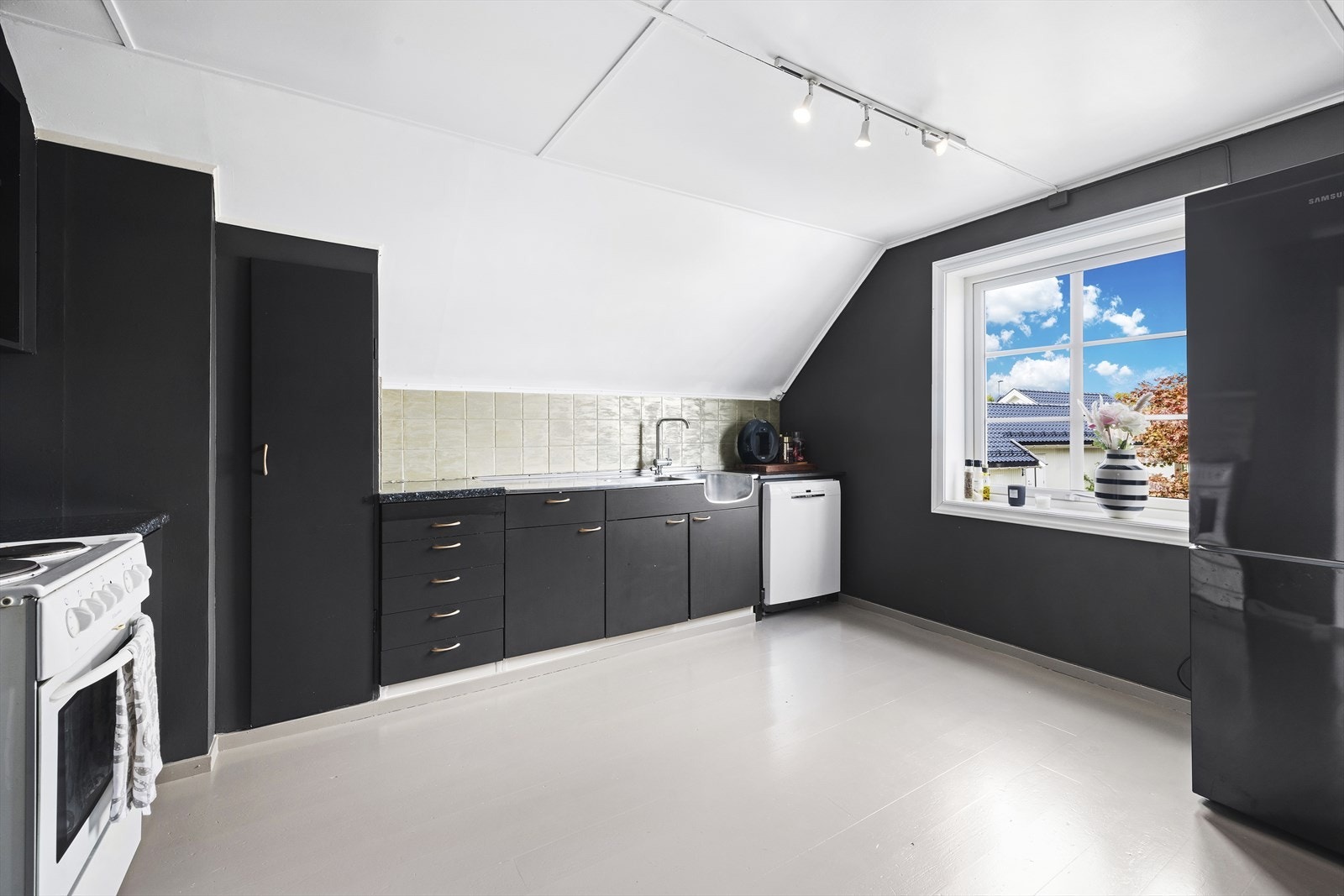 Romslig kjøkken med eldre, men velfungerende innredning Galleribilde