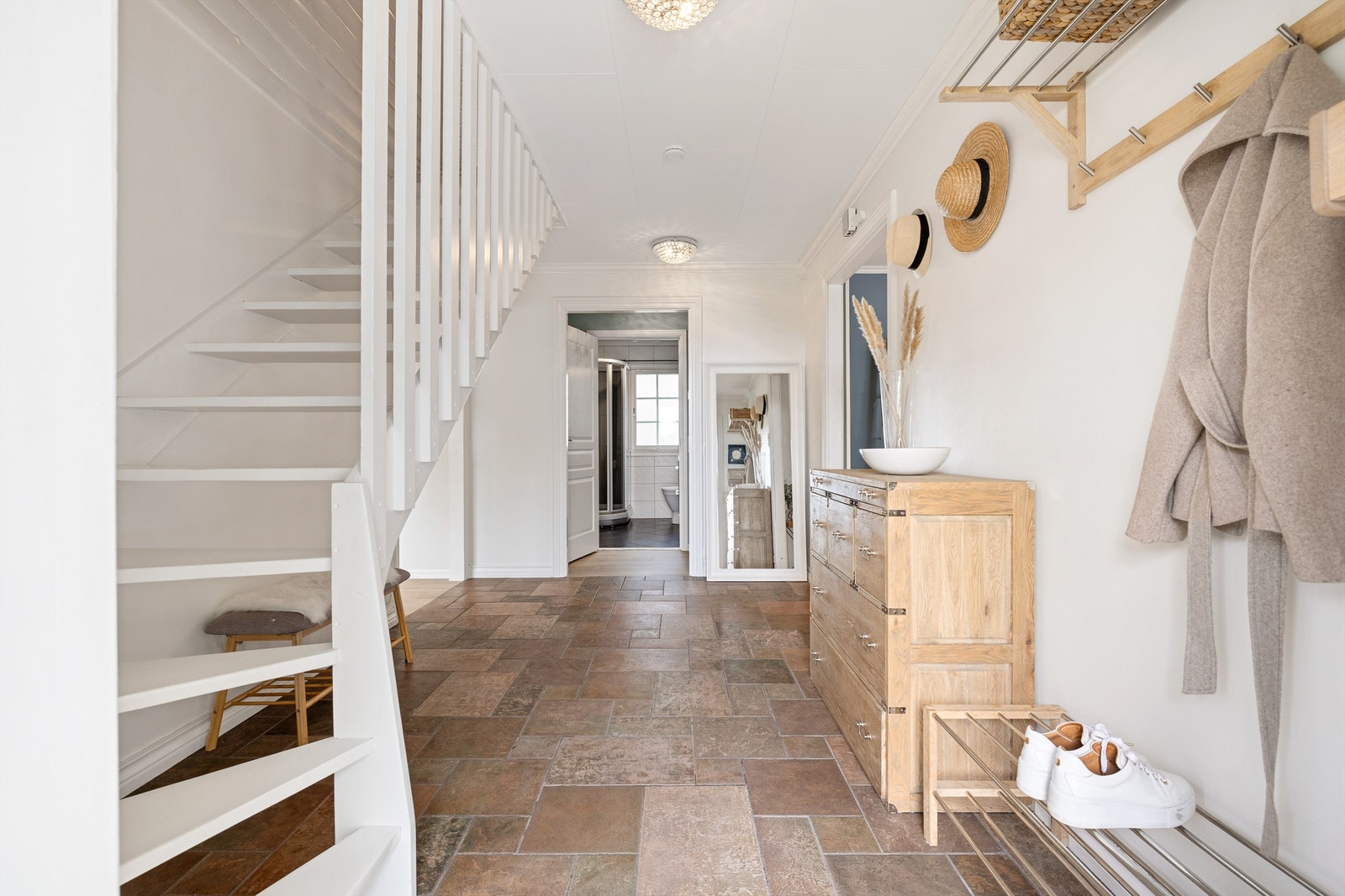 Lys og innbydende entré med flislagt gulv. Galleribilde