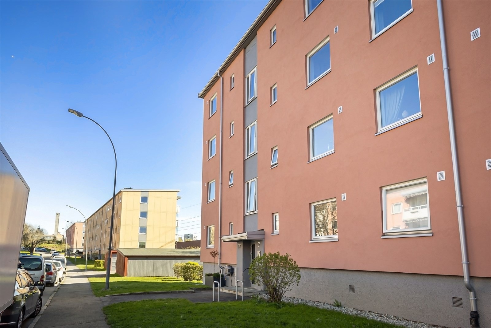 Hyggelig inngangsparti med plenarealer, asfaltert gangsti og belysning ved inngangsdør. Galleribilde