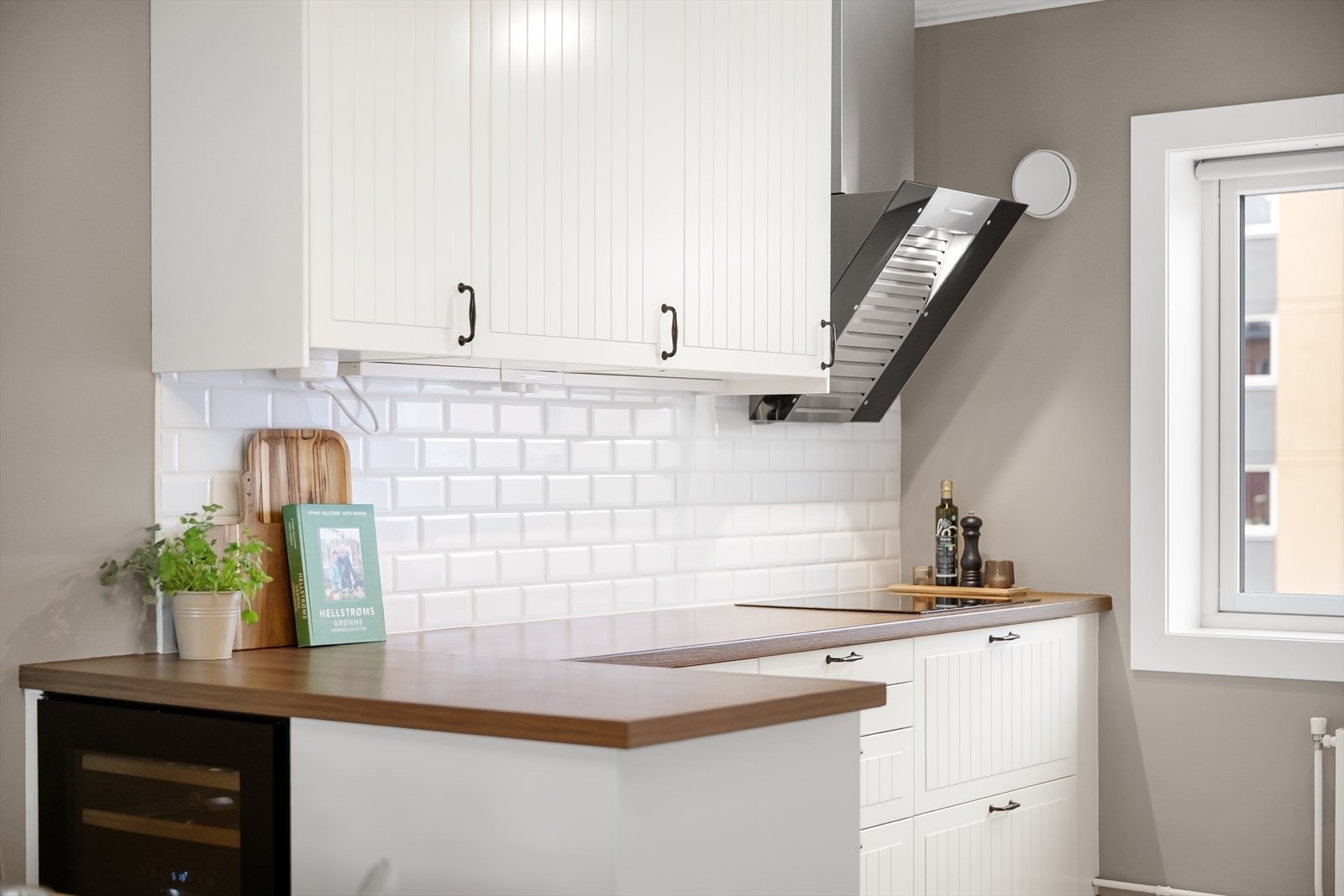 Kjøkkenet har profilerte fronter, enkelte glassfronter i overskap, laminat benkeplate med nedfelt kum i keramikk og integrerte hvitevarer. Automatisk vannstopper er montert. Galleribilde