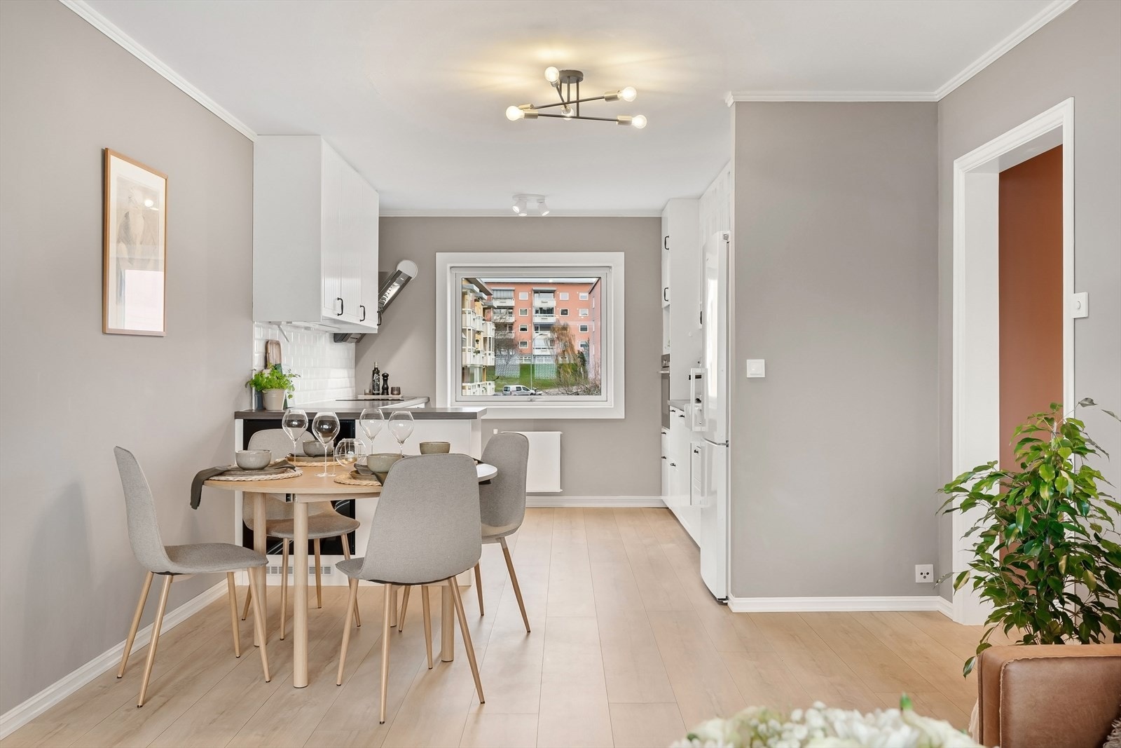 Åpen kjøkkenløsning mot stue, samtidig tilbaketrukket fra sofagruppe. Galleribilde