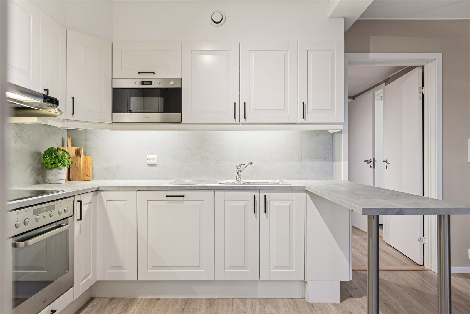 Lyst og praktis kjøkken med integrerte hvitevarer. Galleribilde