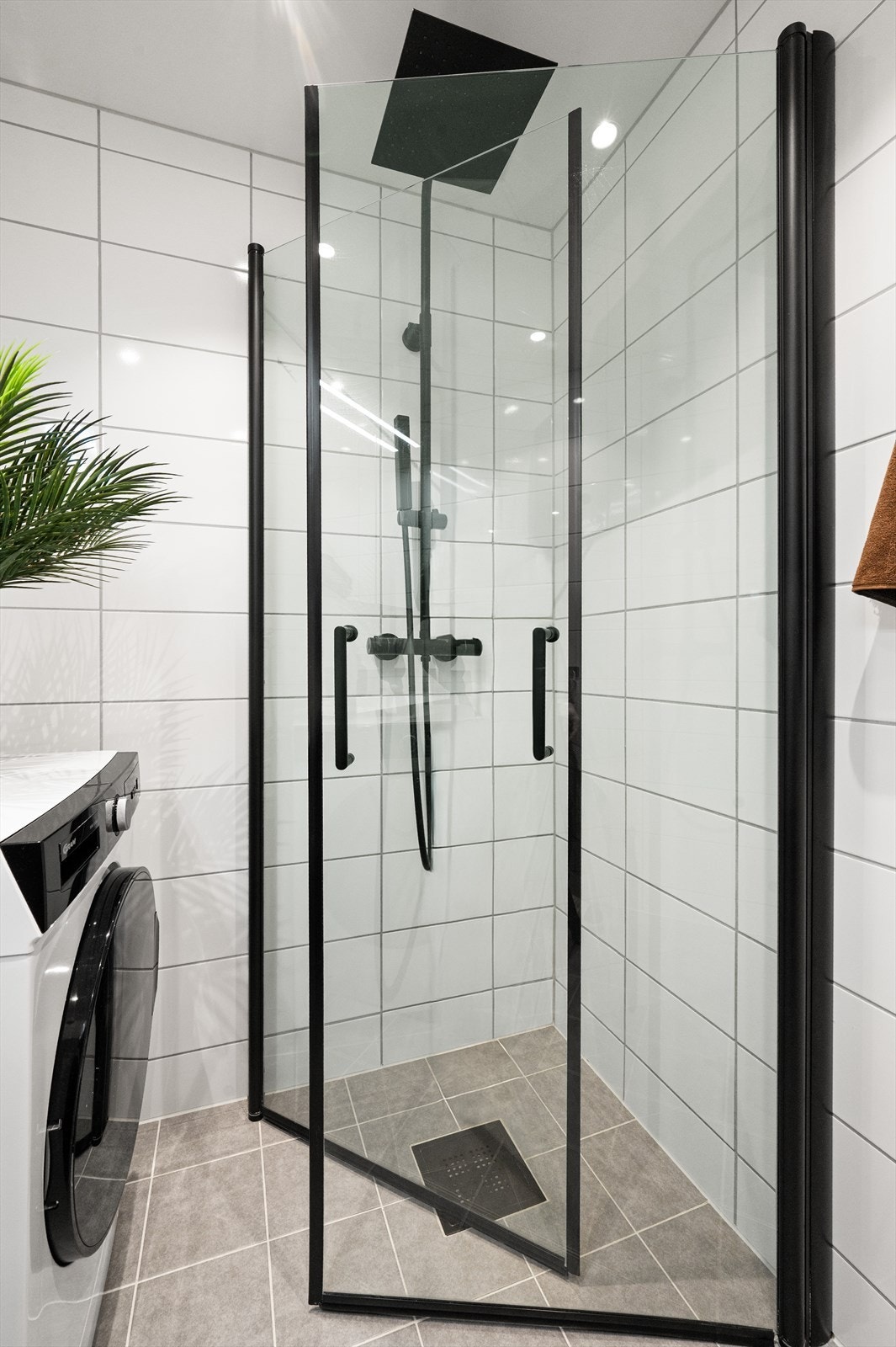 Badet er utstyrt med dusjhjørne som har svingbare glassdører, baderomsinnredning med nedfelt servant og speilskap. Det er opplegg for vaskemaskin. Galleribilde