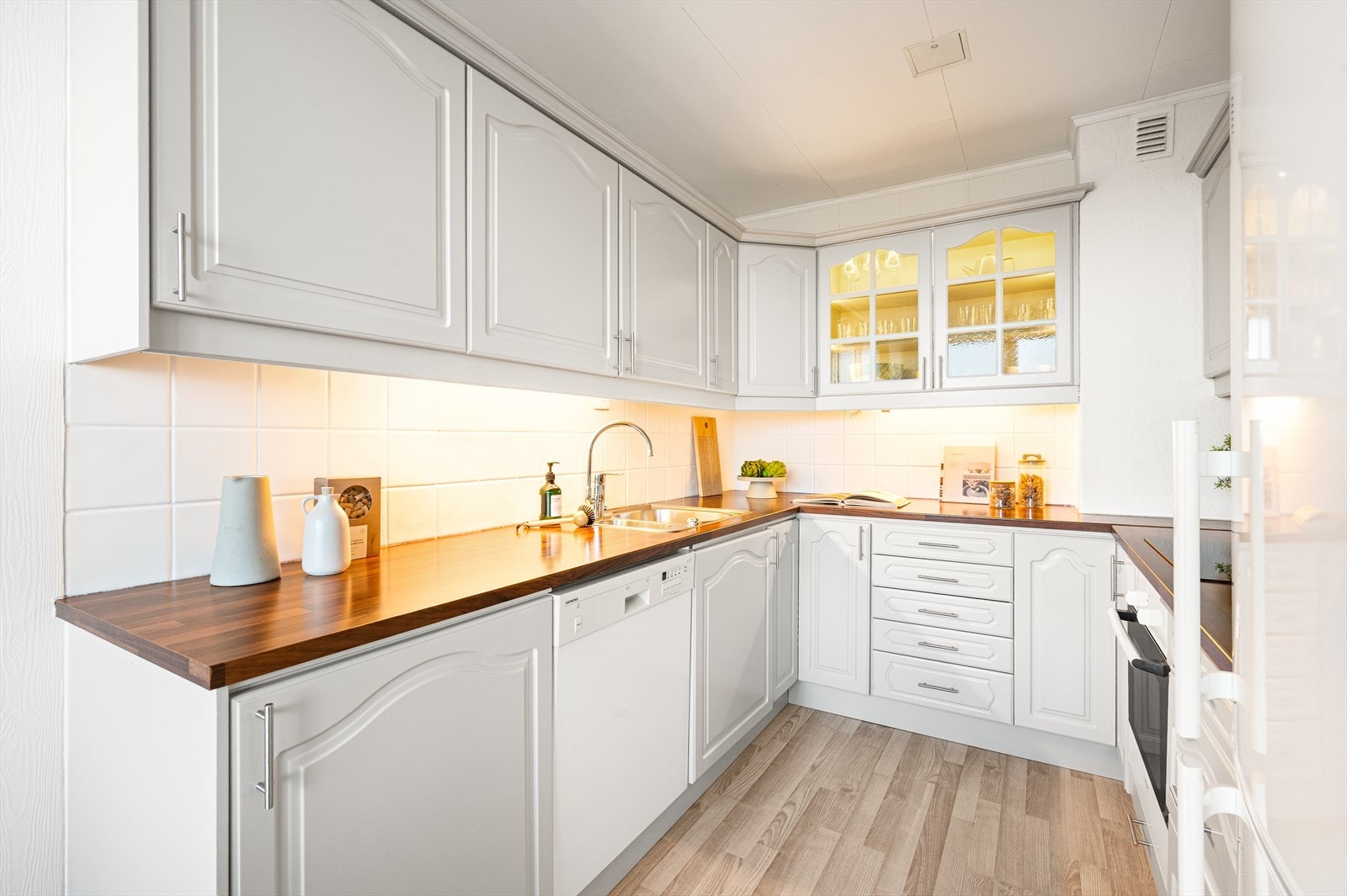 Innredning med profilerte fronter og laminat benkeplate med oppvaskkum i rustfritt stål. Galleribilde