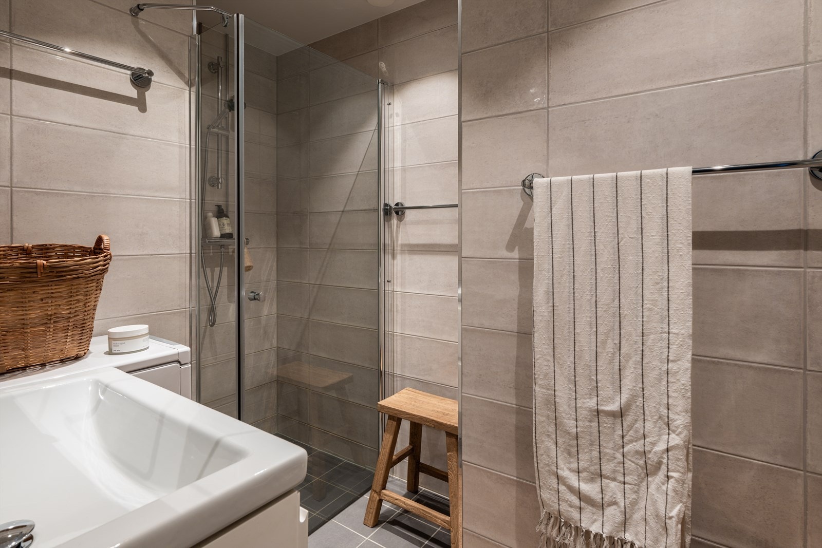 Et pent, moderne bad fra 2020 med lyse flislagte overflater. Galleribilde