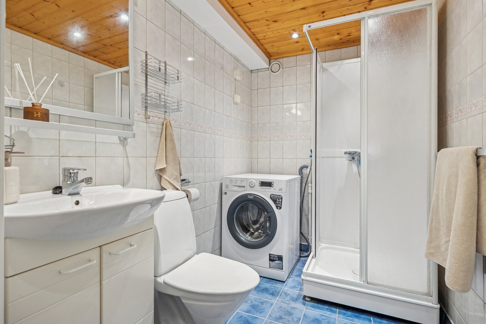 Det 4 kvm store badet har flislagte overflater. Det er opplegg for vaskemaskin, varme i gulv, toalett og dusjkabinett. Praktisk baderomsinnredning med servant i tillegg til speil og belysning. Galleribilde