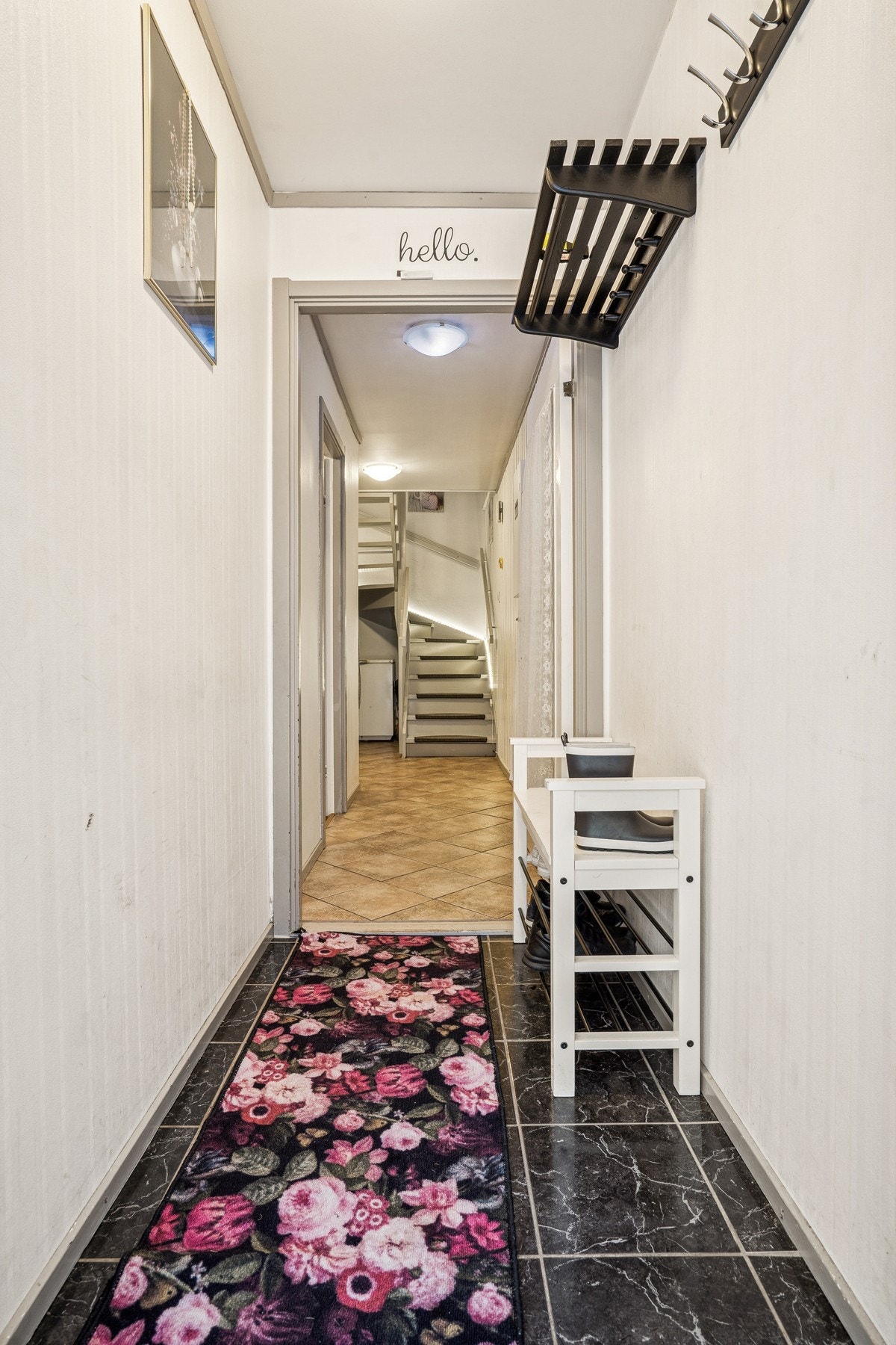 Vindfanget har flislagt gulv og leder videre inn til hallen med trapp til andre etasje. Galleribilde