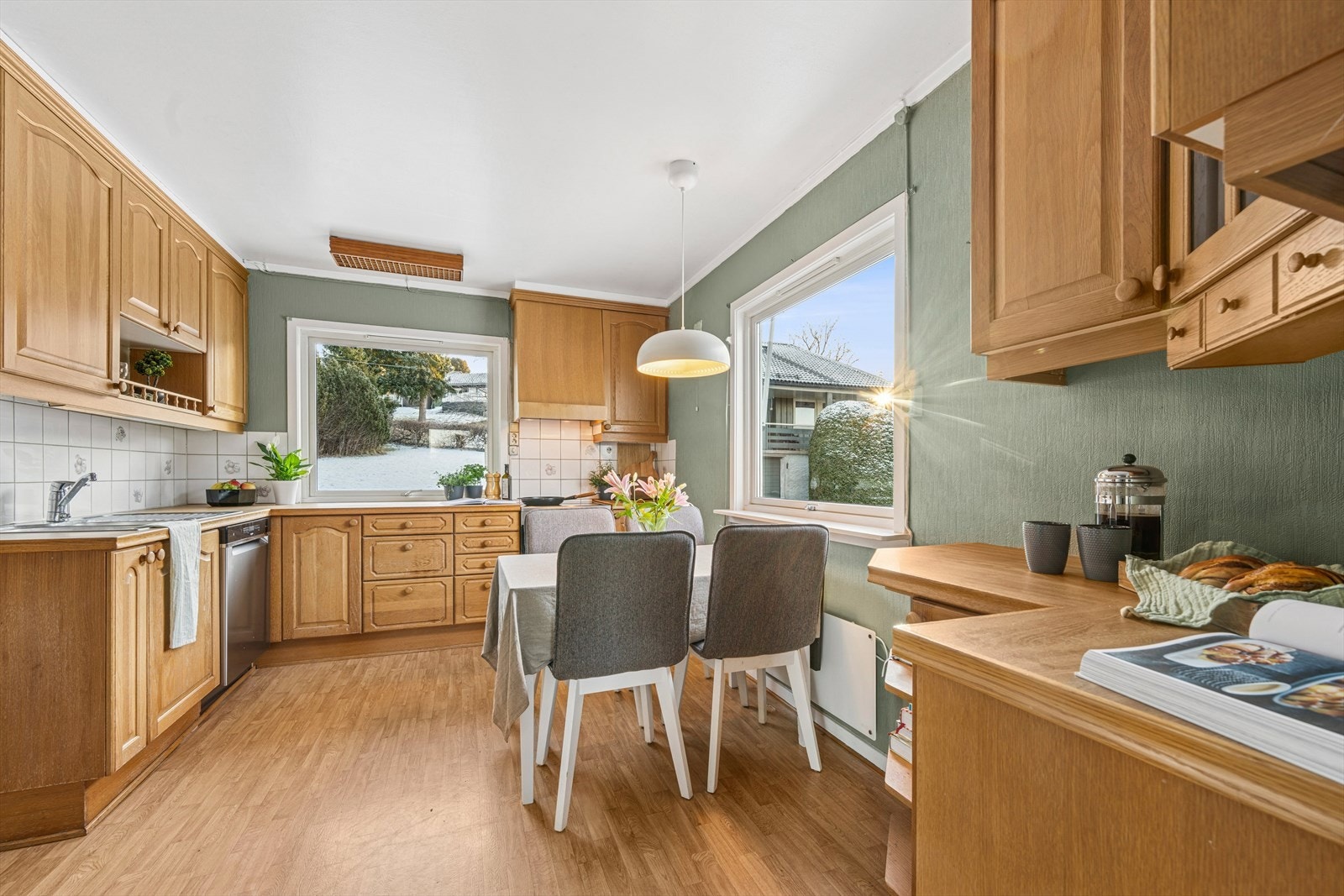 Kjøkkeninnredning med profilerte fronter og laminert benkeplate med fliser på vegg over benkeplaten. Galleribilde