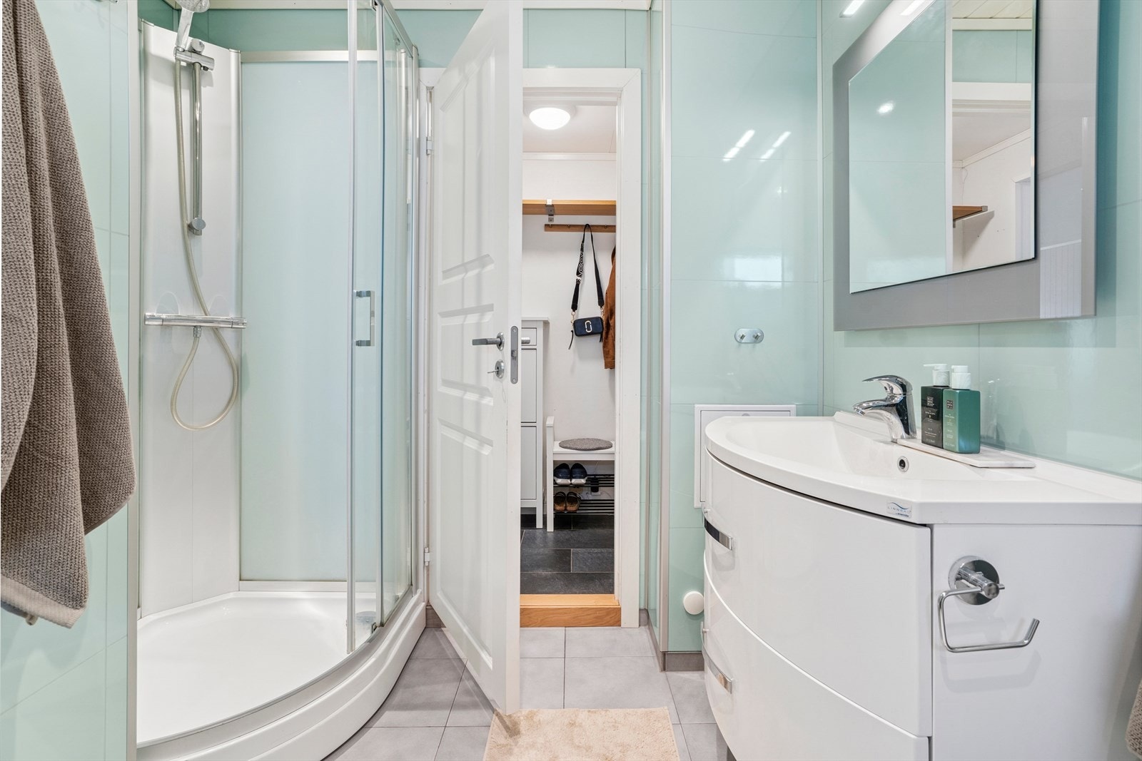 Her er det fliser både på vegger og gulv med varmekabler. Himlingen er lyst og har monterte downlights Galleribilde