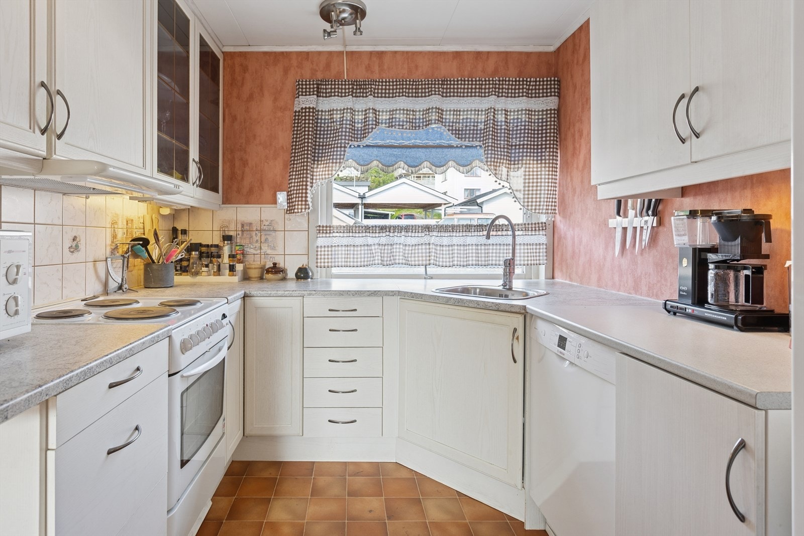 - Lys kjøkkeninnredning med en kledelig benkeplate. Galleribilde