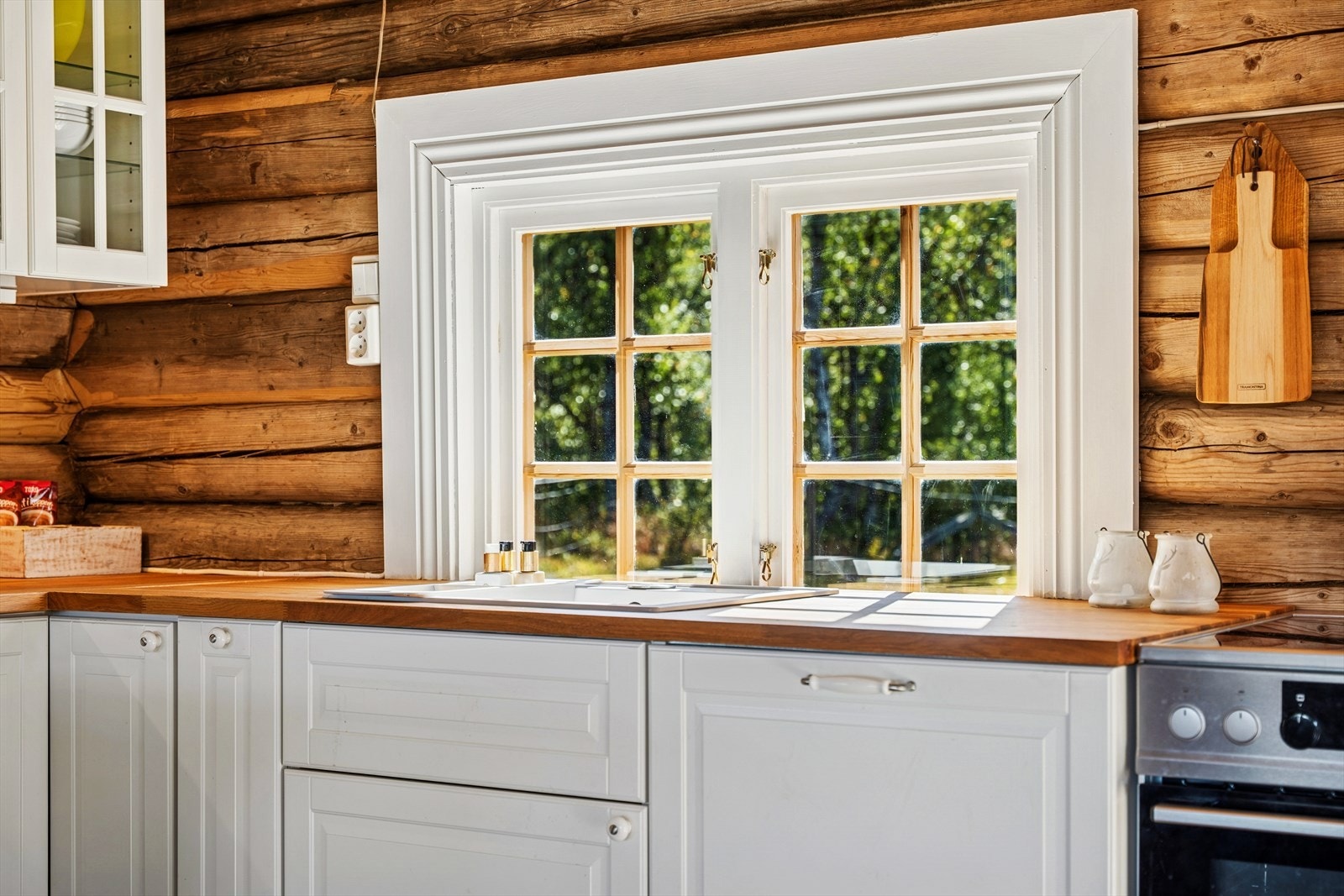 Kjøkkeninnredning har profilerte fronter i hvit utførelse. Galleribilde