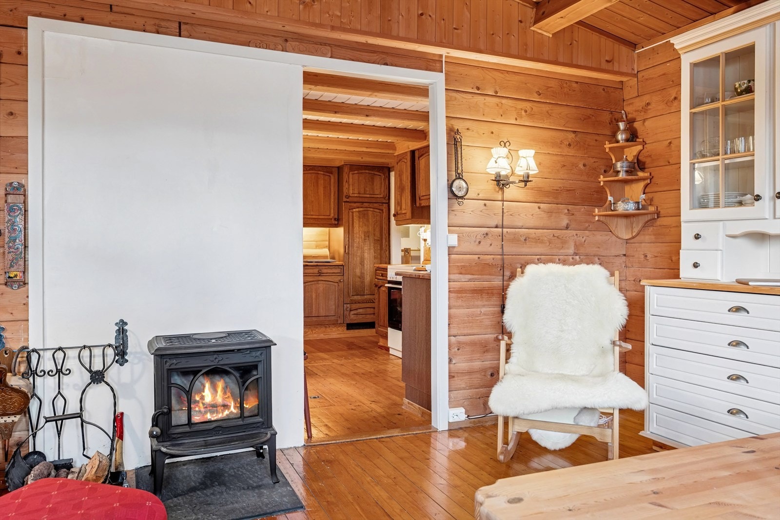 Peisovnen i rommet gir den rette hyttestemningen og god varme etter en lang dag i skiløypen. Gyngestol med hvit skinn medfølger ikke i handelen. Galleribilde