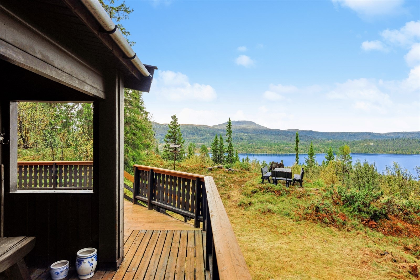 Tomten fremstår som naturlig og usjenert, med vegetasjon som gir både skjerming og en hyggelig ramme rundt hytten. Galleribilde
