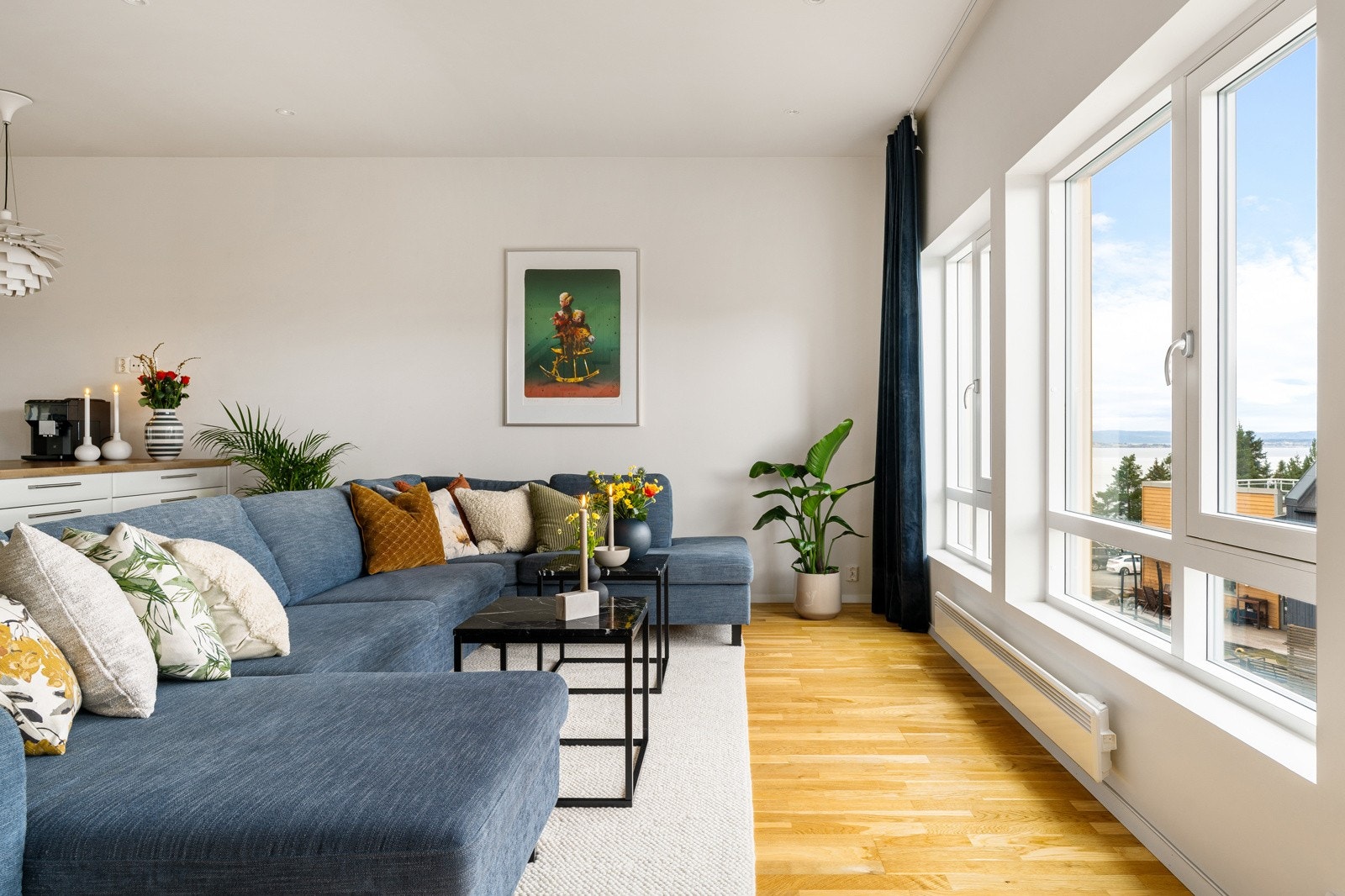 Her er det åpen stue- og kjøkkenløsning med store vindusflater og moderne, listefrie overganger til vinduer og tak. Galleribilde