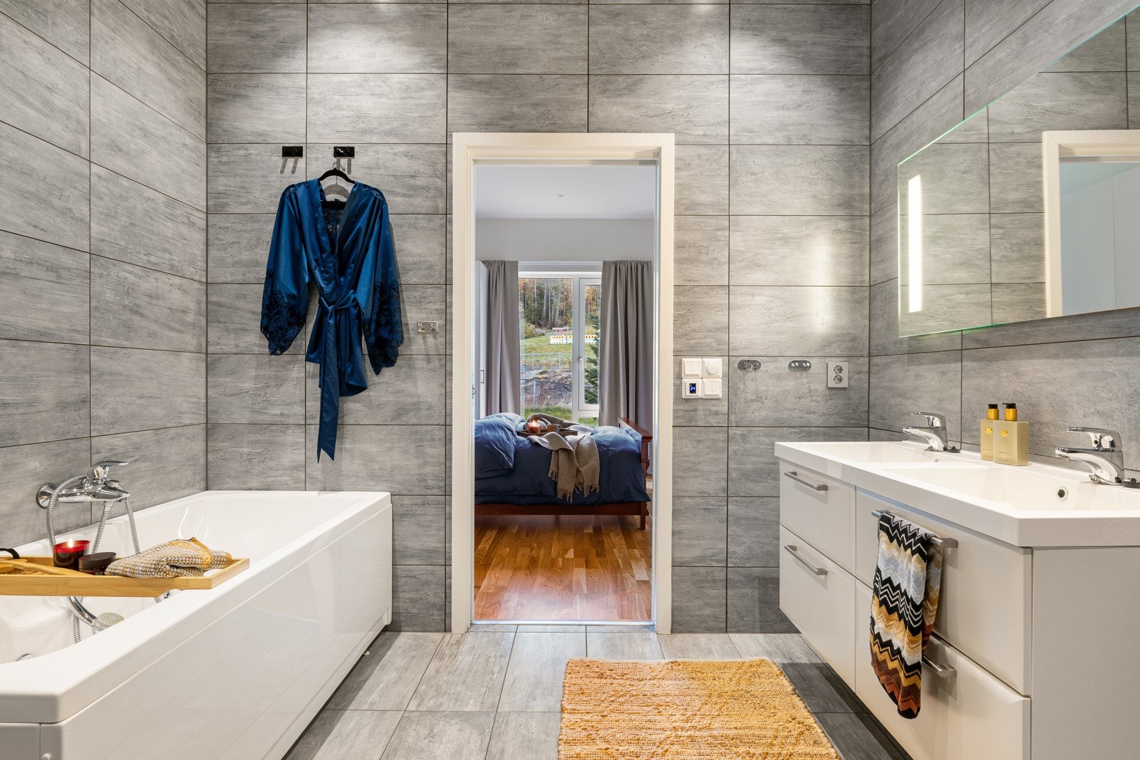 Her er det innredet med dobbel servant, opplyst speil, badekar, toalett og dusjhjørne. Galleribilde