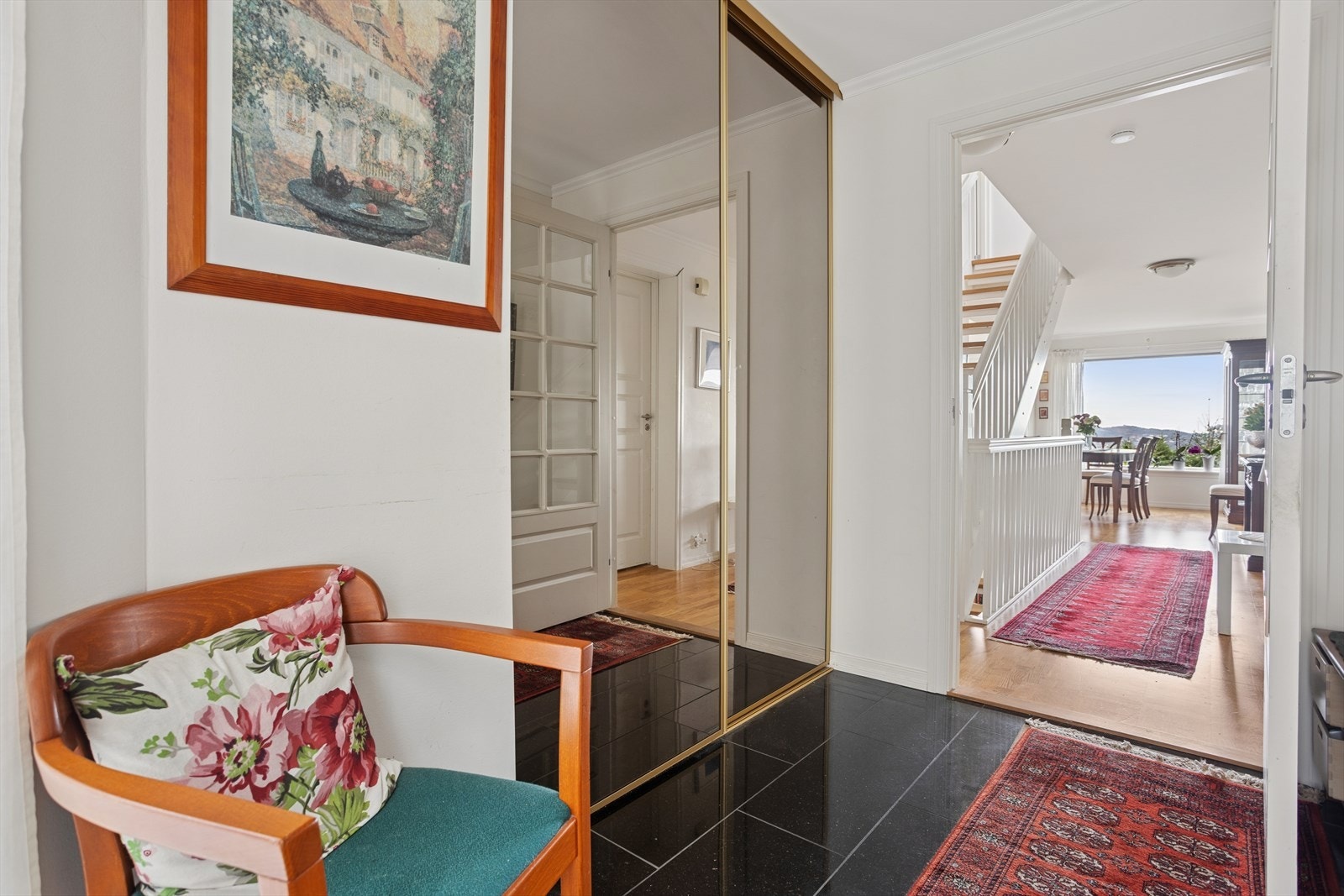 Man blir ønsket velkommen i en smart entré med praktiske fliser på gulvet og god oppbevaringsplass til yttertøy i skyvedørsgarderobe. Galleribilde