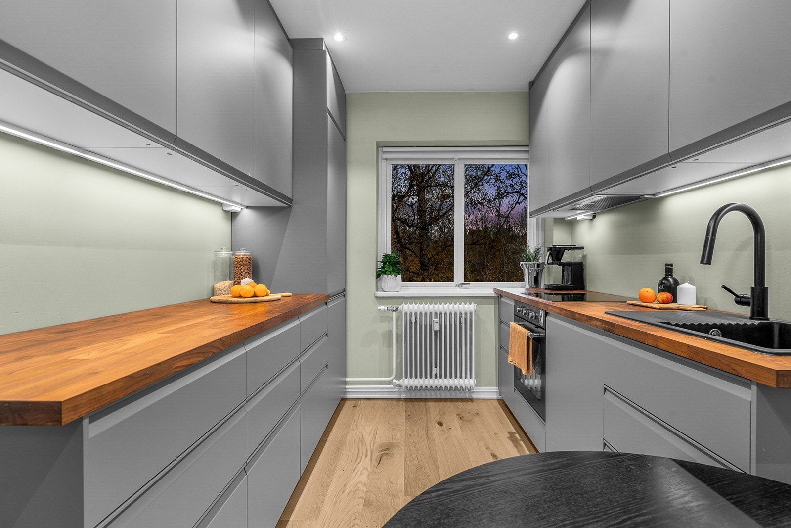 Kjøkkenet har moderne innredning med glatte fronter og benkeplate i laminat med nedfelt vaskekum Galleribilde