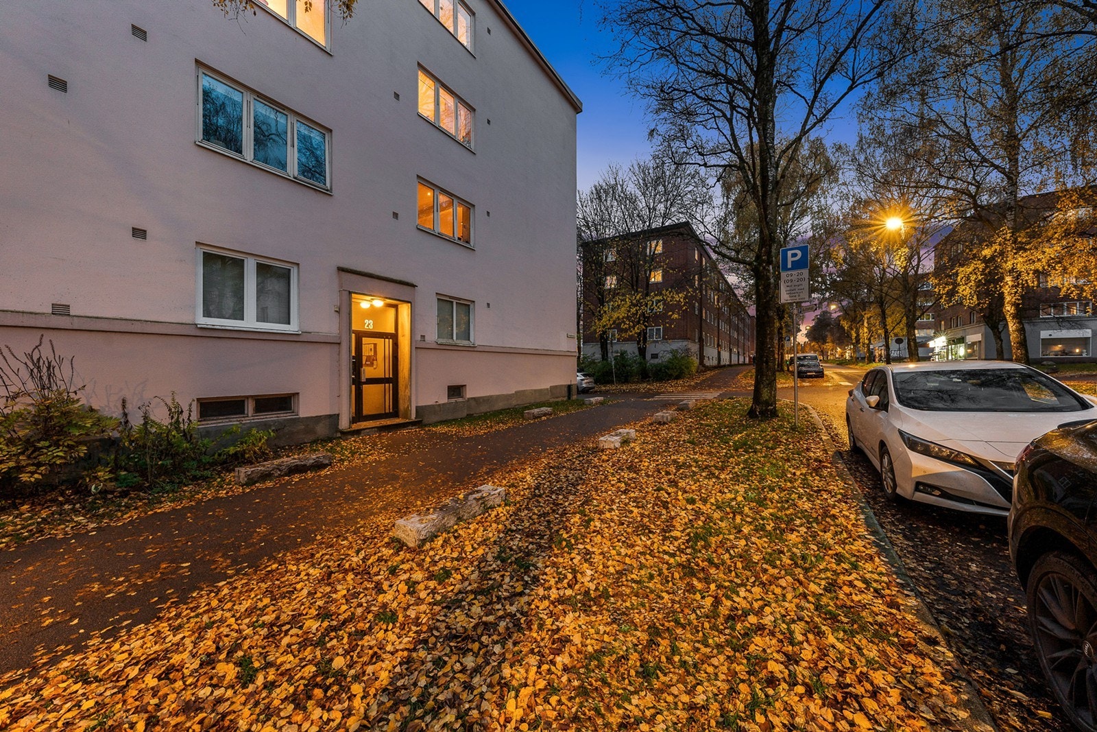 Tomten er opparbeidet med asfalterte gang- og stikkveier, sittegrupper, trær og variert vegetasjon Galleribilde