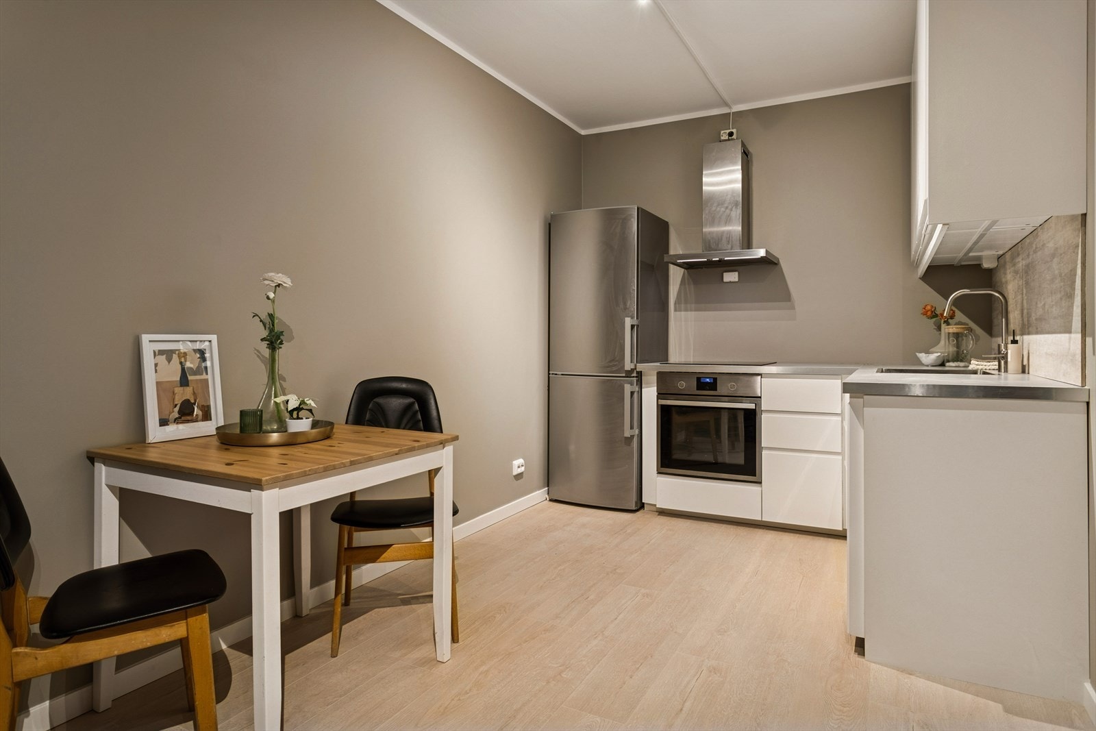 Kjøkkenet har folierte skrog med slette fronter og en laminert benkeplate. Ventilator med kullfilter. Galleribilde