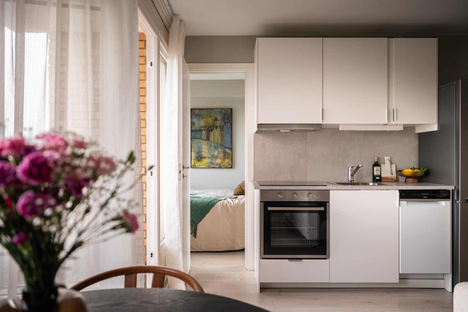 Lys og moderne kjøkkeninnredning fra Ikea som var ny i 2024. Innredningen har hvite glatte fronter og laminert benkeplate med nedfelt oppvaskkum. Galleribilde