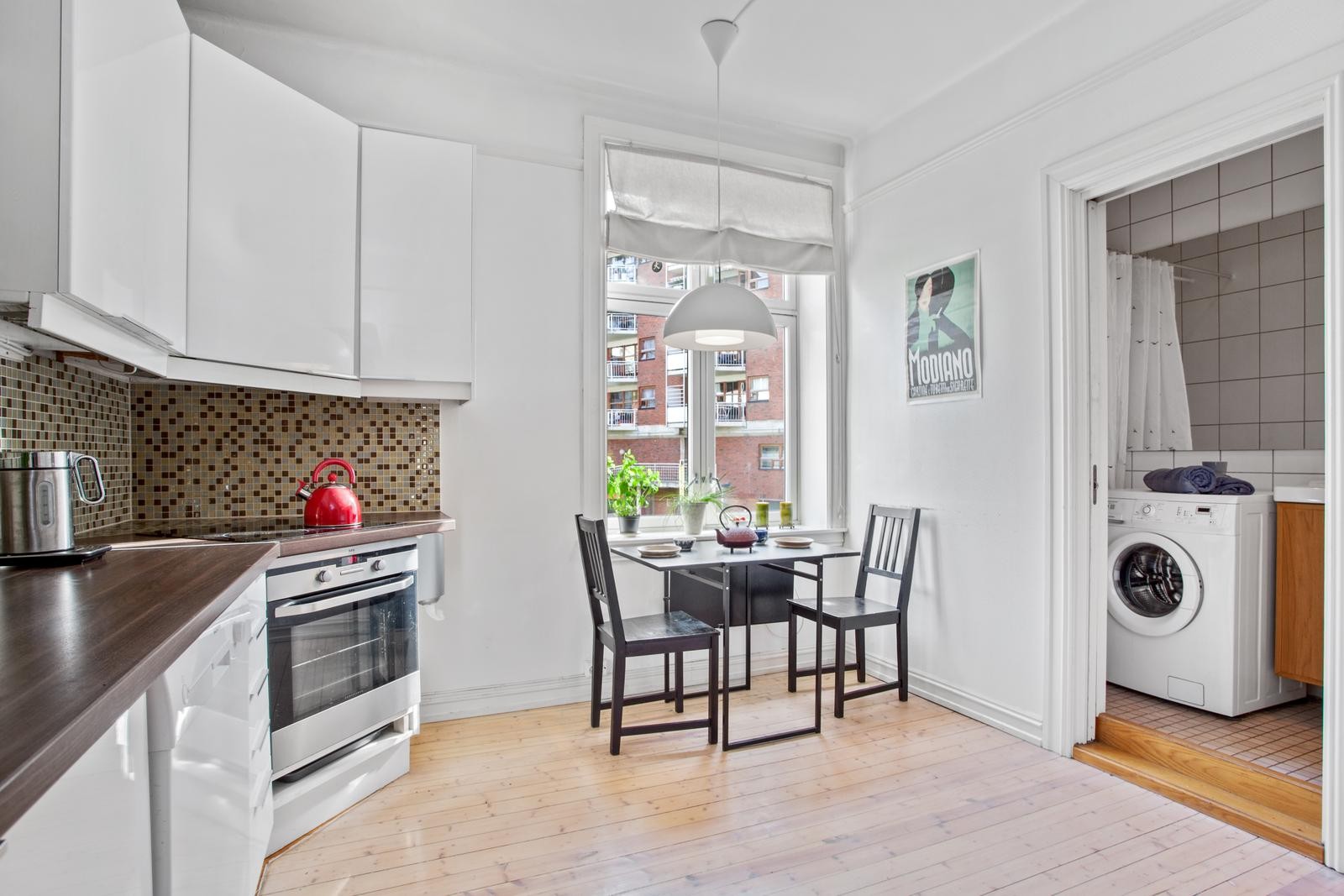 Separat kjøkken med lyse fronter og plass til spisegruppe Galleribilde