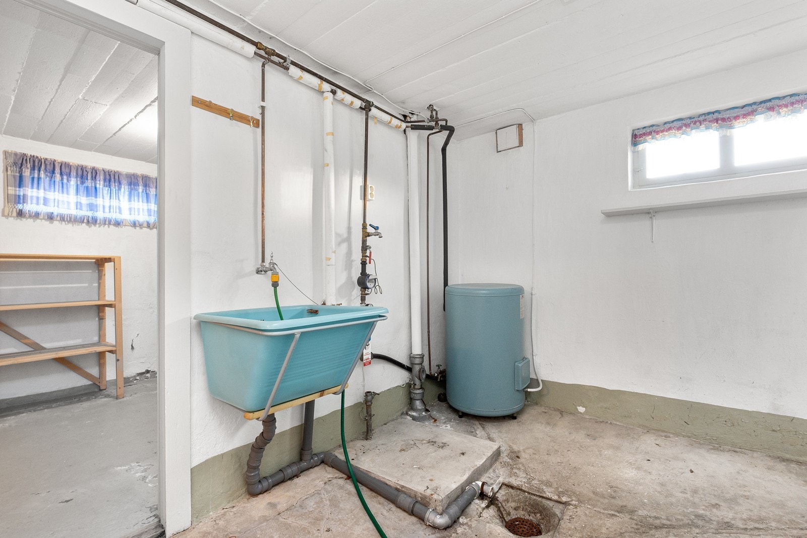 Vaskerommet er utstyrt med eldre varmtvannstank og utslagsvask i plast, med opplegg for vaskemaskin. Galleribilde