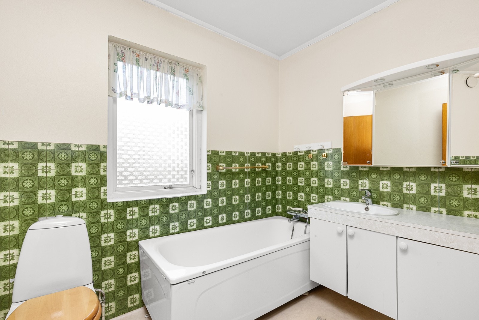 Badet i 1. etasje har eldre våtromstapet og pusset mur på veggene, samt elektriske varmekabler i gulvet. Galleribilde