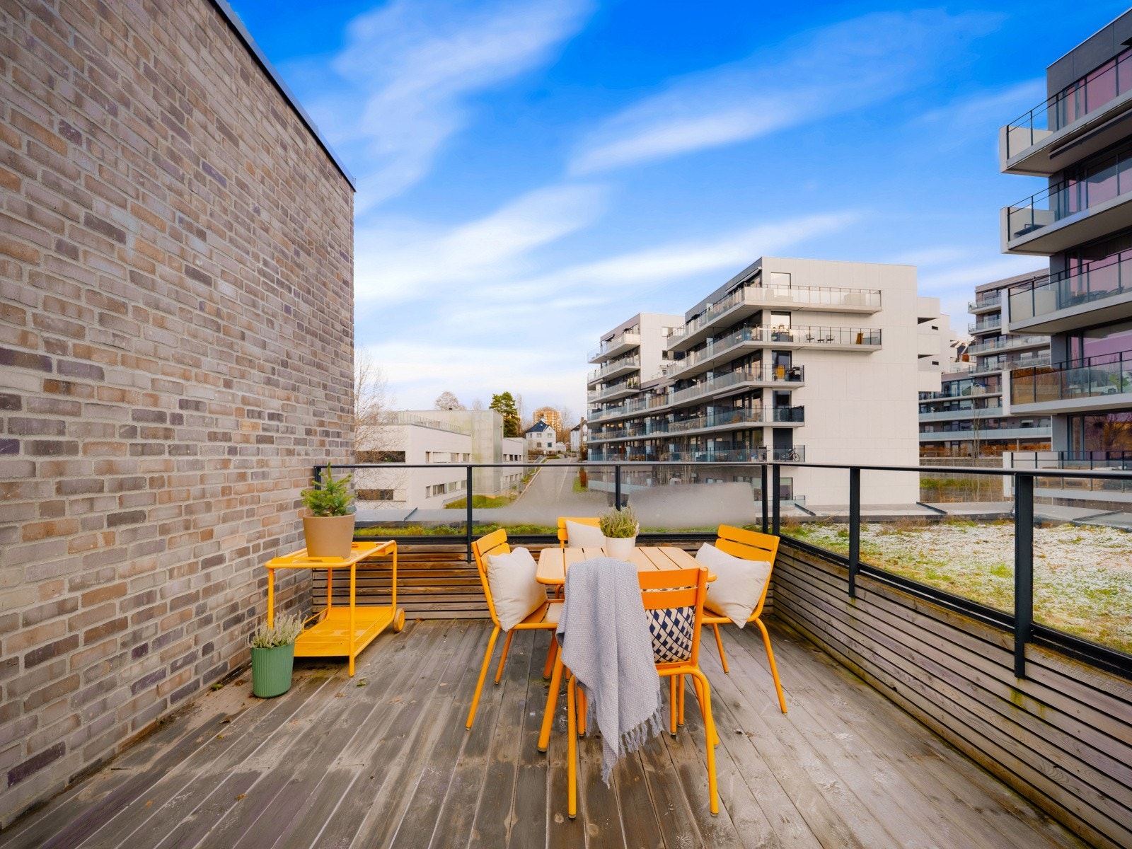 Leiligheten har også tilgang til en felles takterrasse i samme etasje, kun noen meter fra inngangsdøren. En flott plass å bruke når man har gjester. Her er det formiddagssol og terrassen er møblert med sittegruppe. Galleribilde