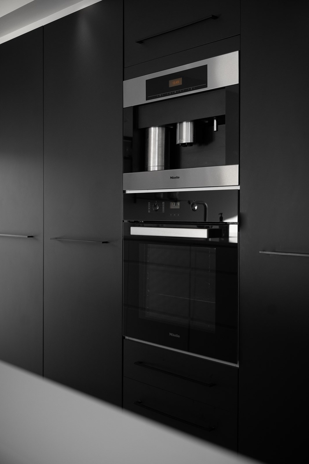 Integrert kaffemaskin og stekeovn fra Miele, som delikat flyter sammen med høyskapene. Kvik kjøkken type Mano. Skiftet ut fronter på høyskap i 2019. Miele stekeovn og ASKO oppvaskmaskin (oktober 2025). Siemens koketopp. Galleribilde