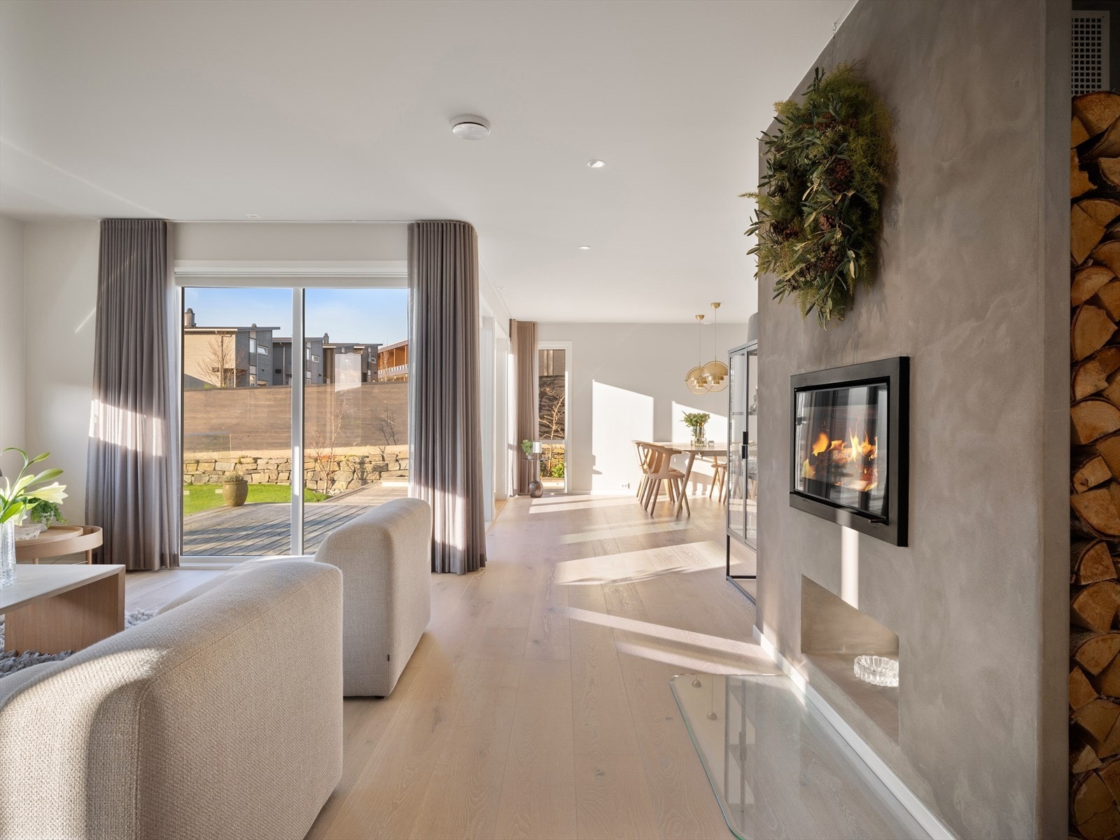 Moderne og stilren peis som gir en lun atmosfære med mulighet for vedfyring. Perfekt på kalde vinterkvelder. Praktisk lagring av ved i veggnisje. Galleribilde