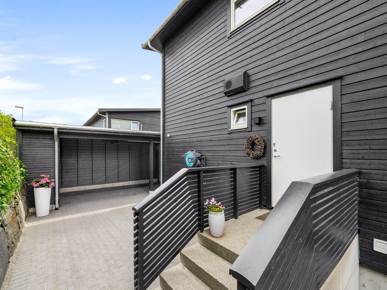 Fra carport er det også enkel tilkomst til boligens bi-inngang, skjermet på baksiden. Galleribilde