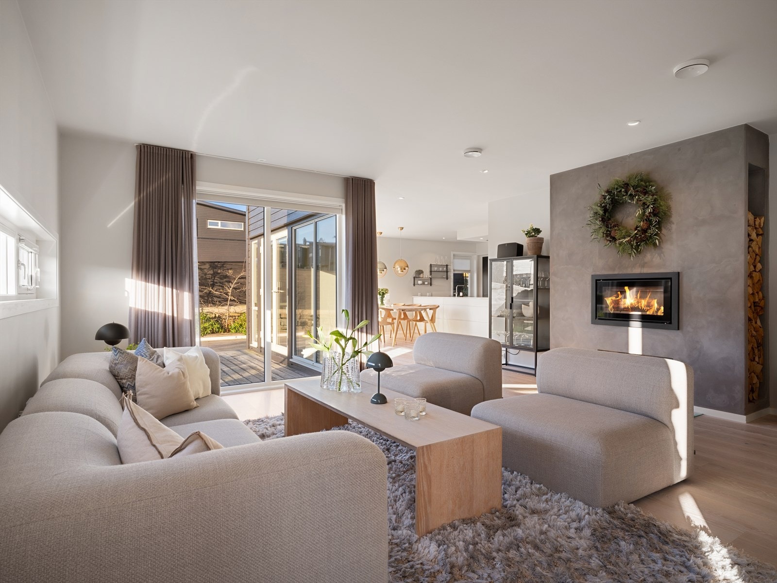 En herlig romfølelse med kombinasjonen av store vinduer og naturlig lys, peisovn for ekstra varme og atmosfære, samt naturlige soner for møblering. Galleribilde