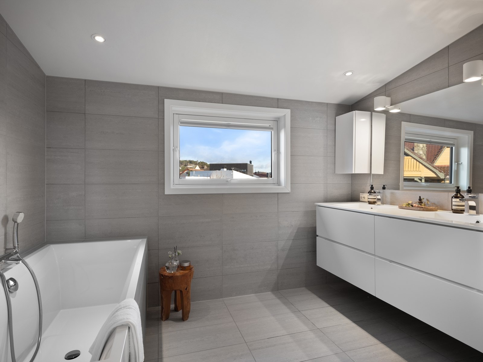 Delikat og tidløst hovedbad med både dusj og badekar. Kjekk dobbelvask for travle morgener, og rikelig med skapplass. Vindu for naturlig lys til sminkingen gjør det komplett. Galleribilde