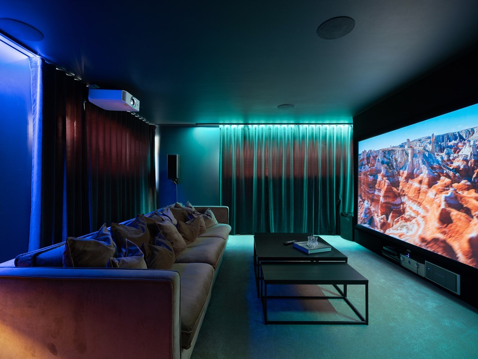 Kjellerstuen som i dag er innredet som et kjekt kinorom. Lyddør, tepper på gulv og baffelvegg for lydisolering. Integrerte høyttalere i tak medfølger salget. Galleribilde