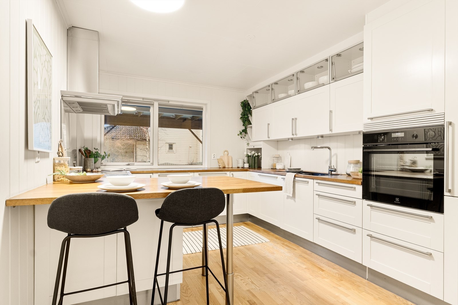 Pent og tidløst HTH-kjøkken med lyse profilerte fronter og benkeplate i heltre. Galleribilde