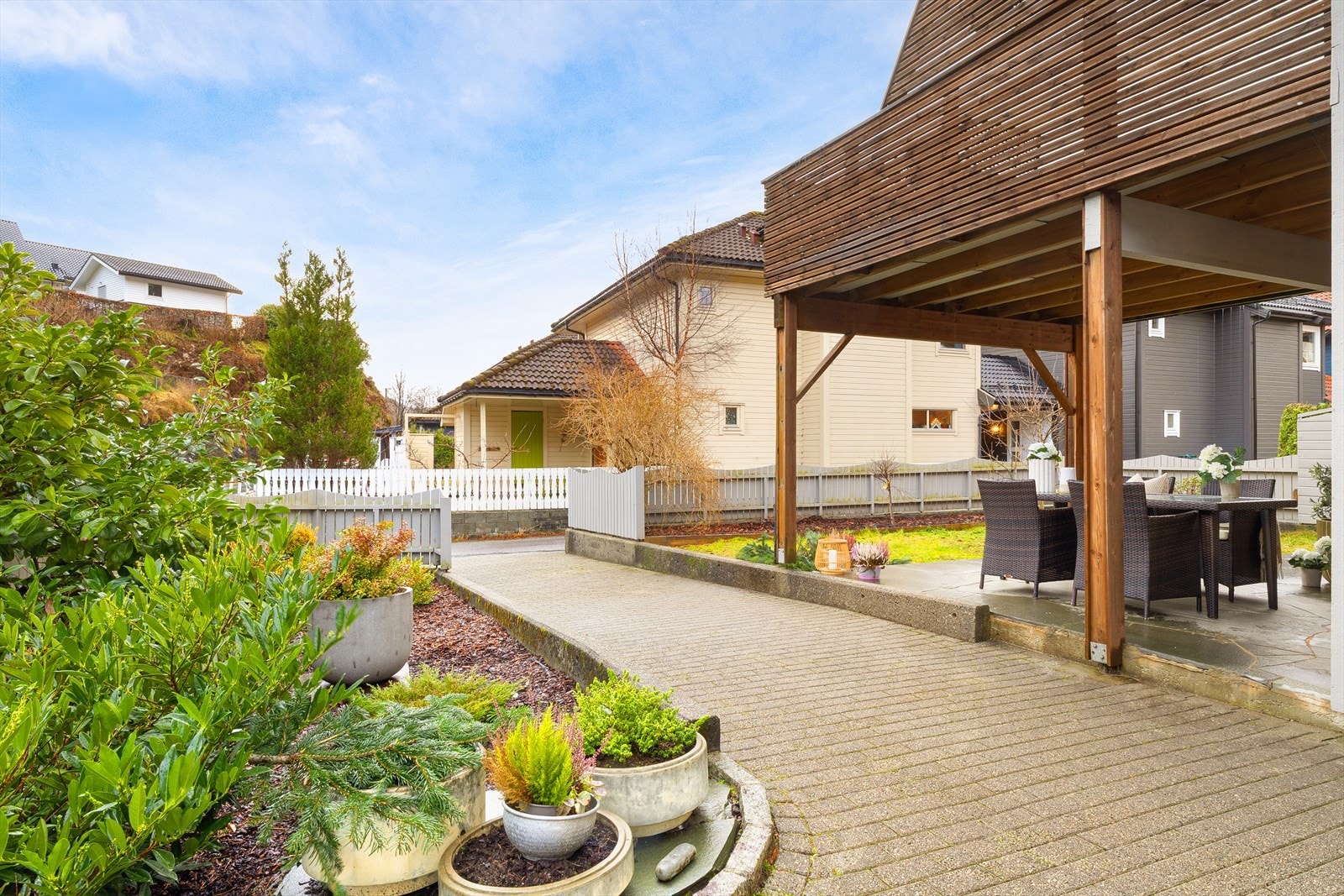 Inngangspartiet er pent opparbeidet med internvei, diverse beplantning og gjerde. Galleribilde