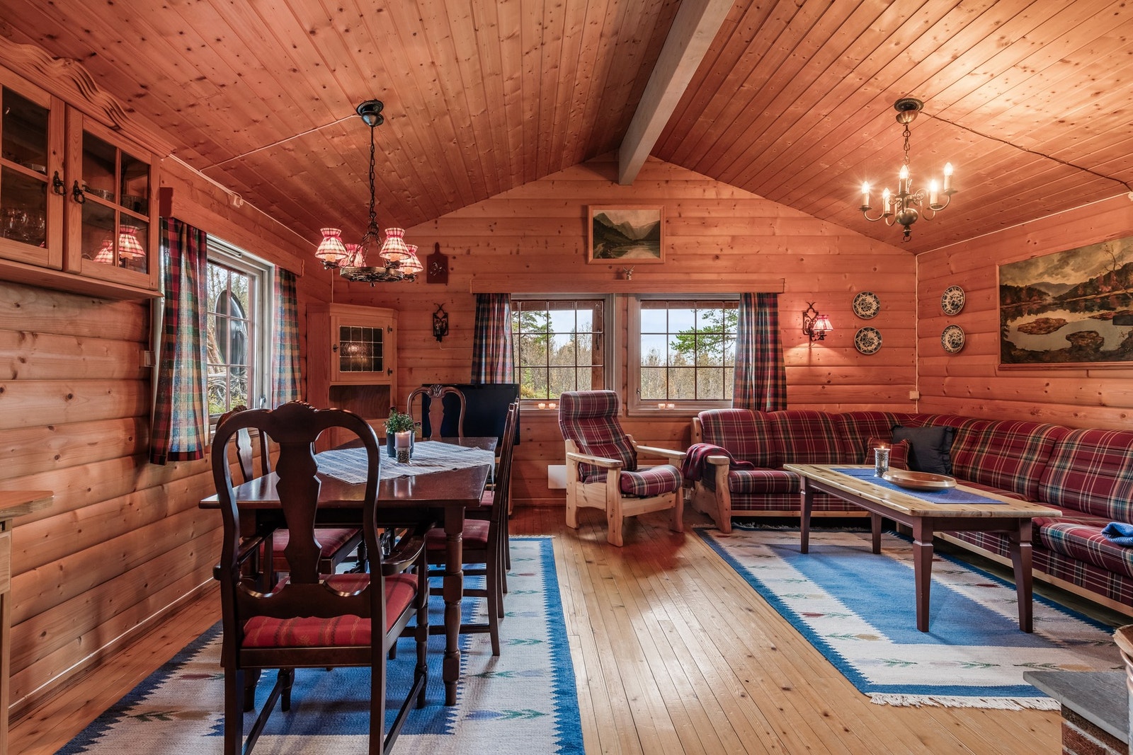 Stue/spiseplass med lune trevegger og koselige sitteplasser. Galleribilde