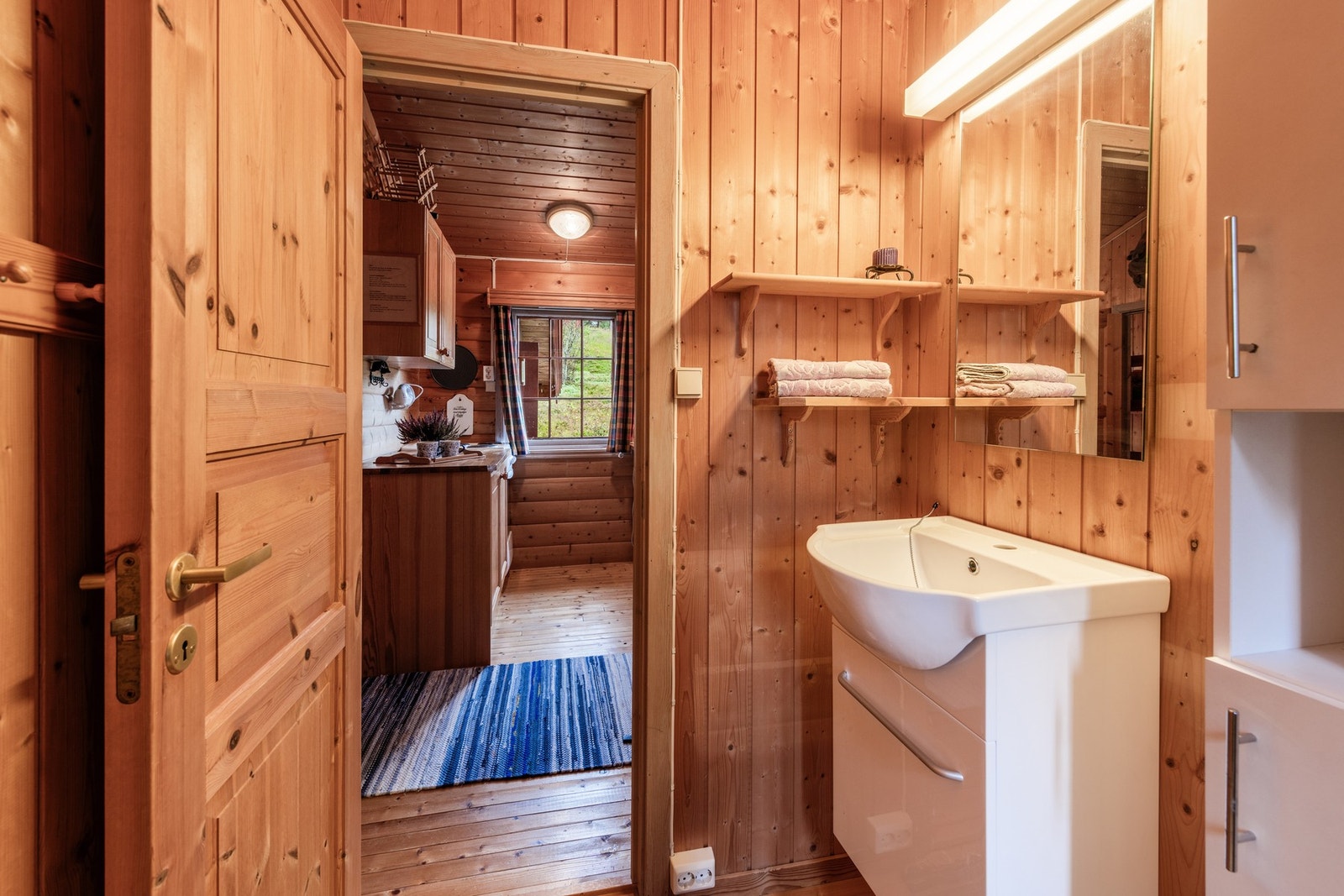 Badet har servantinnredning, håndvask uten tilkoblet vann, dusjkabinett med el. pumpe til bøtte Galleribilde