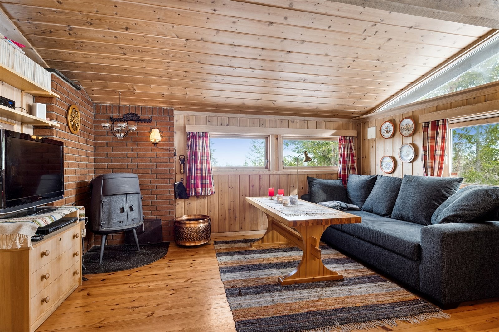 Stuen er gjennomført med lyse gulv og pen panel på vegger og tak. Galleribilde