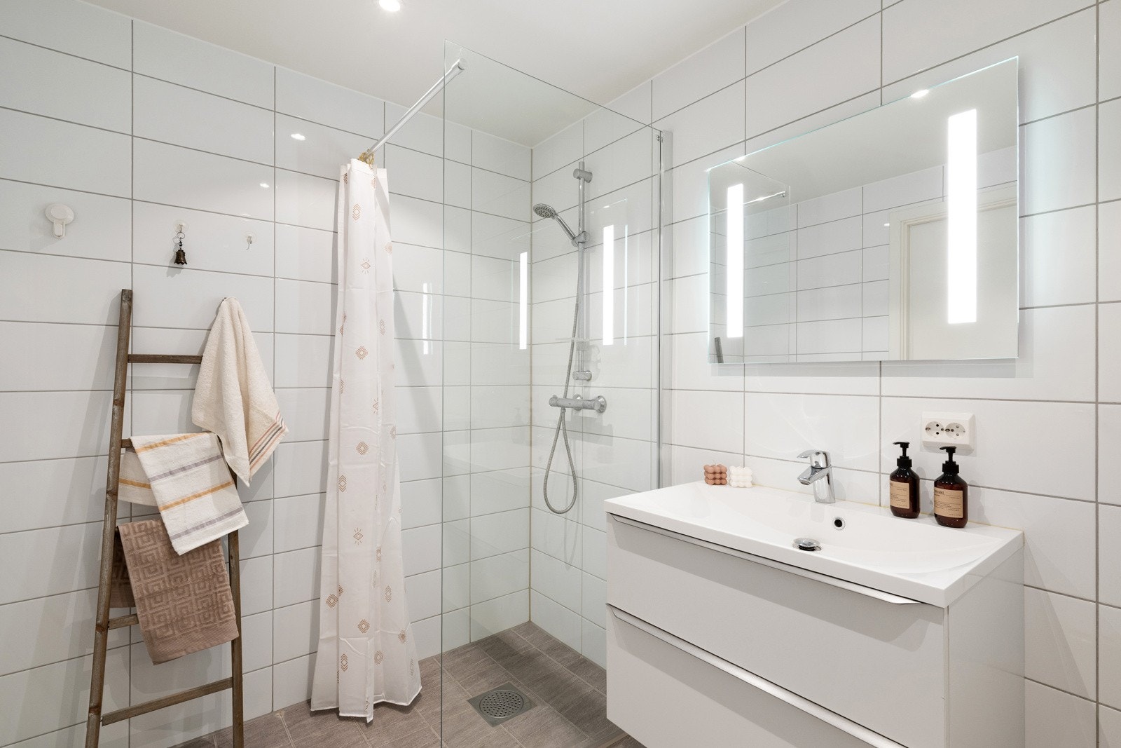 Det andre badet er helfliset med vannbåren varme i gulv og innredet med seksjon med helservant, vegghengt toalett med skjult sisterne og og glassvegg i dusj. Galleribilde