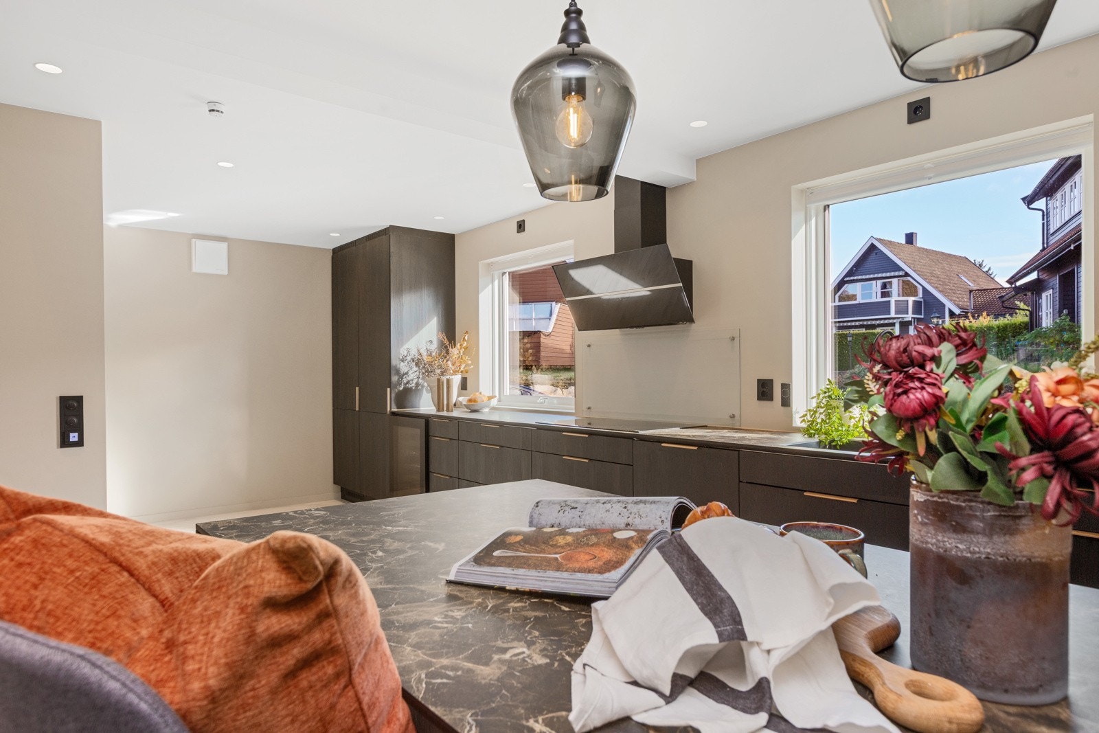 Mulighet for barstoler tilknyttet kjøkkenøyen - legg merke til downlights i himling Galleribilde