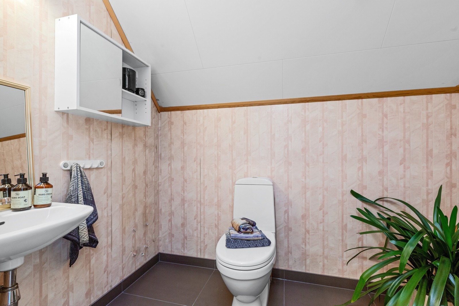 Badet i 2. etg. har nytt flislagt gulv med varmekabel. Det er installert en enkel vask, toalett og dusj på vegg. Galleribilde