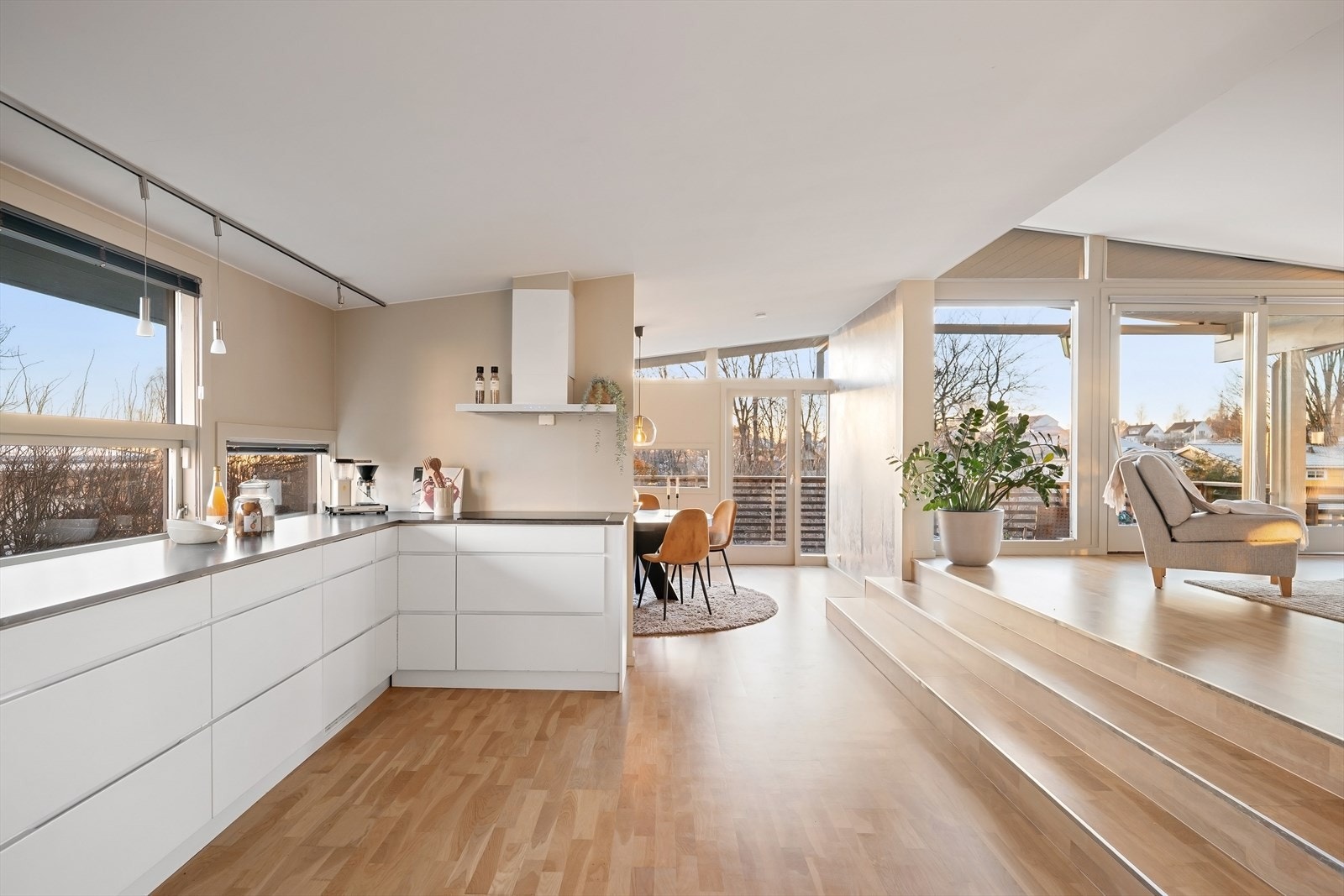 Delikat og romslig kjøkken fra Kvik (2013) med hvite, glatte fronter og laminat benkeplate med oppvaskkum. Galleribilde