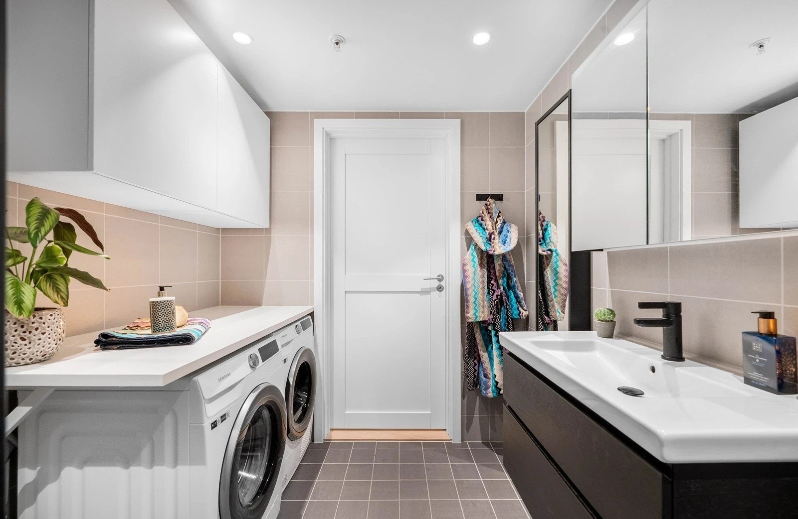 Lekkert flislagt bad med downlights i tak og praktisk fin innredning. Mye skapplass Galleribilde